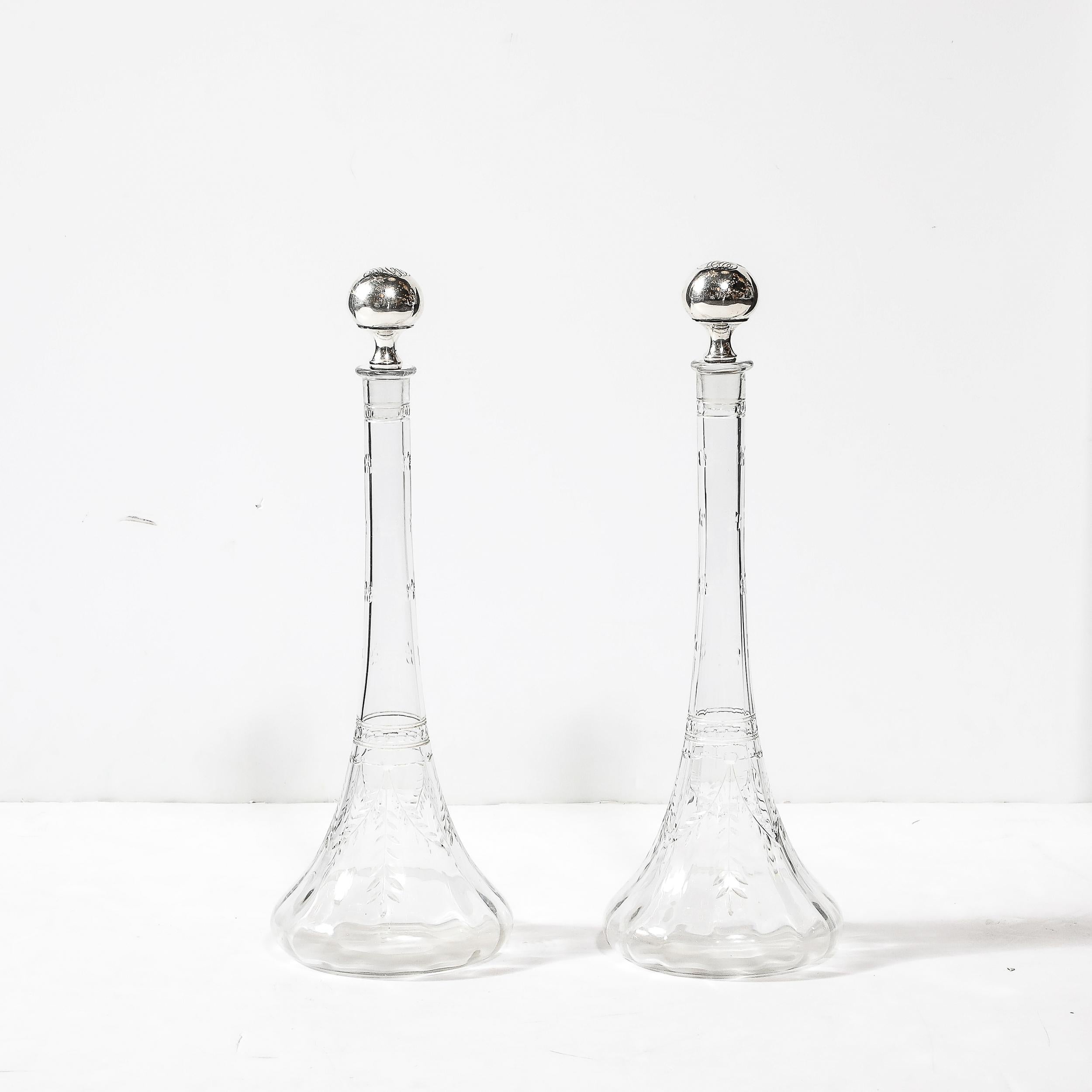 Esta excepcional pareja de decantadores de cristal tallado Art Nouveau, fabricados en América hacia 1910, combina el arte con la funcionalidad en una celebración del diseño de principios del siglo XX. Los decantadores presentan una llamativa forma
