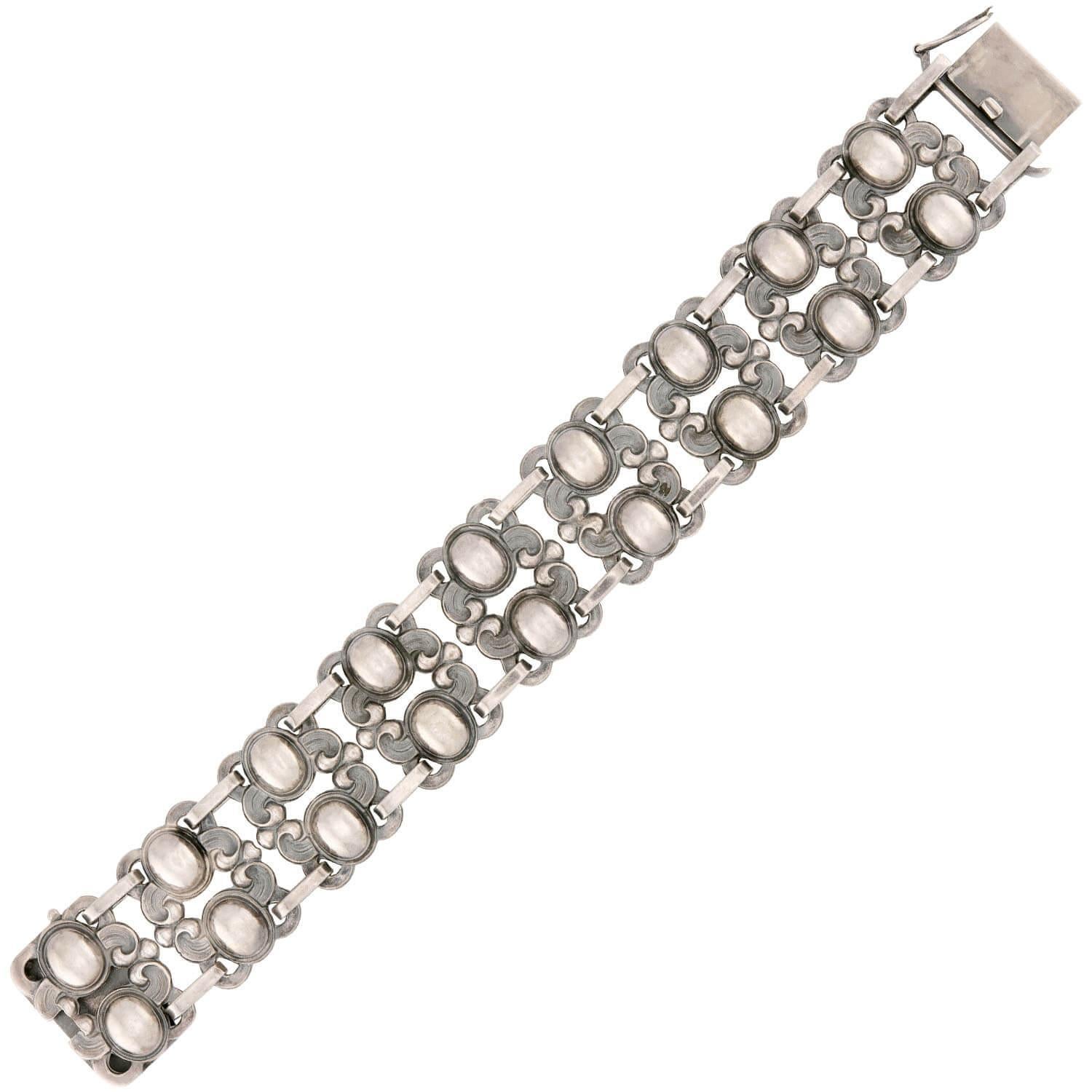 Un meraviglioso bracciale in argento sterling dell'epoca Art Nouveau (ca. 1900)! Realizzato in argento sterling, questo pezzo è composto da 9 maglie identiche. Ogni maglia presenta due ovali tridimensionali e motivi di scorrimento unici,
