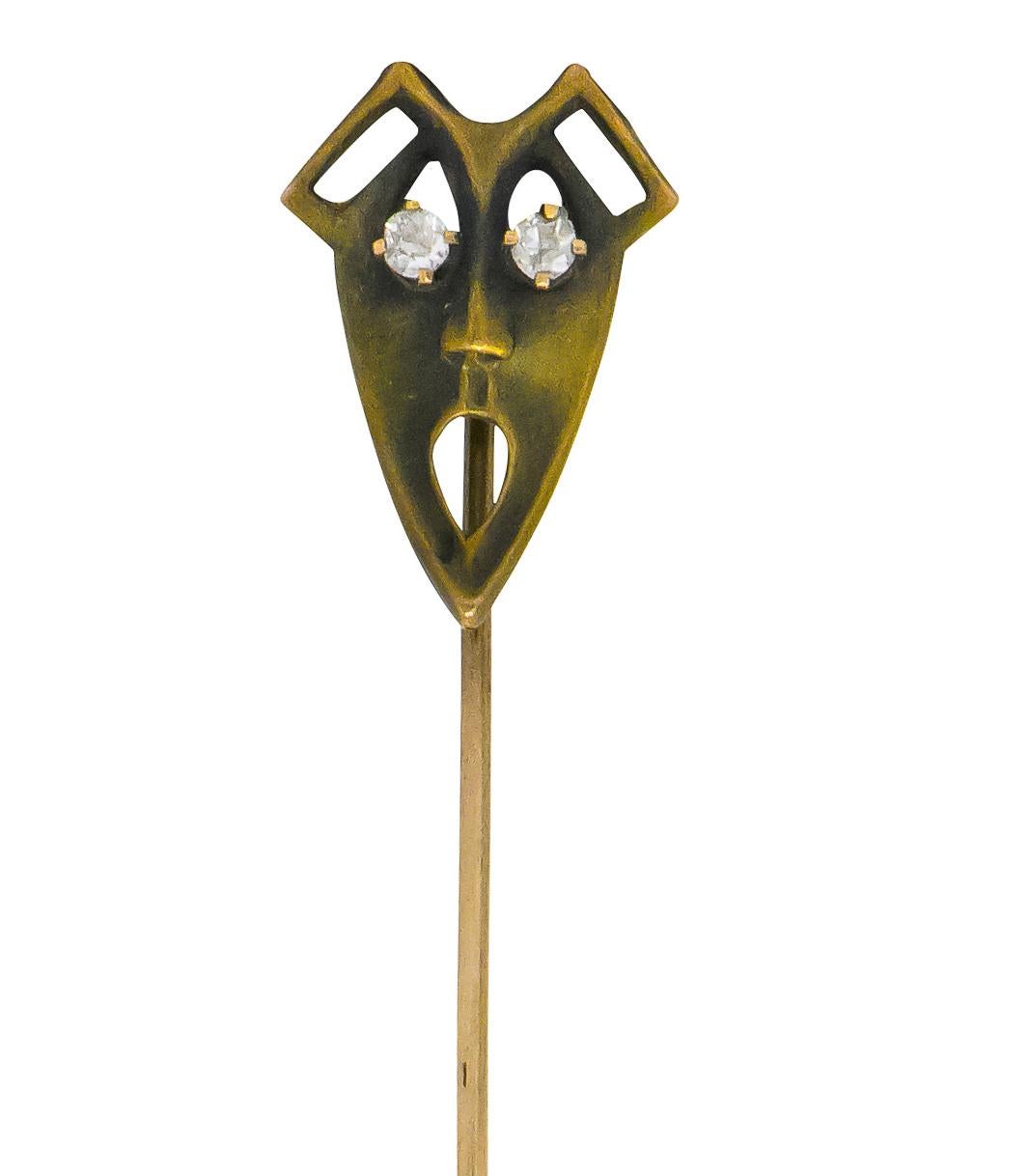Designed as a stylized Green Man face with a pierced pear shaped mouth

Featuring two claw set old European cut diamonds, eye-clean and white

Matte gold with an aged finish

Tested as 10 karat gold

Head measures: approx. 11/16 x 7/16 inch

Total