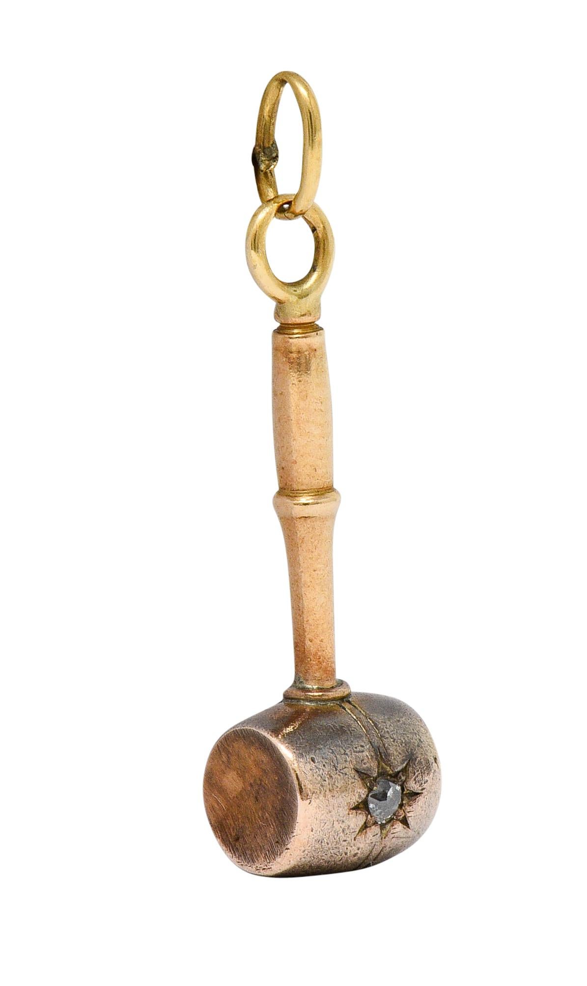 Designed as a stylized mallet gavel accented by an old European cut diamond

Weighing approximately 0.05 carat and graver set as a starburst motif

Completed by a jump ring bale

Tested as 14 karat gold

Circa: 1905

Measures: 3/8 x 1 1/4 inches