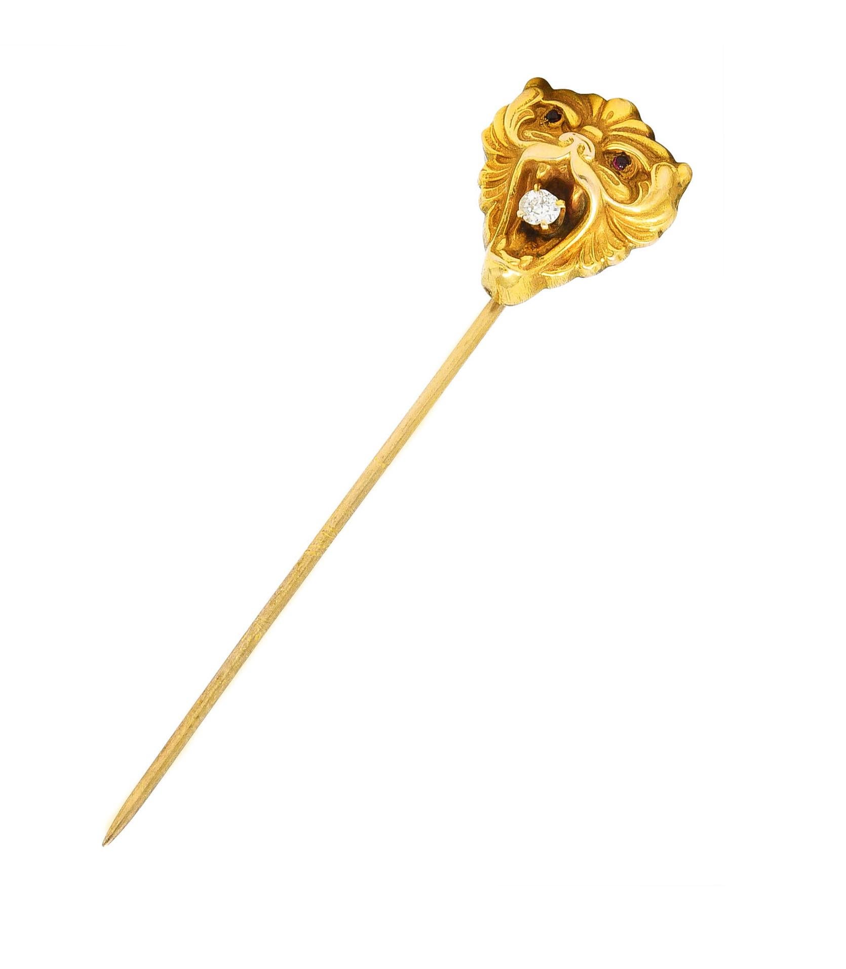 Stickpin is designed as a stylized lion head with swirling grooved fur

Featuring a prong set old mine cut diamond clutched in its teeth

Weighing approximately 0.06 carat - eye clean and bright

Accented by red cabochon eyes

Tested as 14 karat