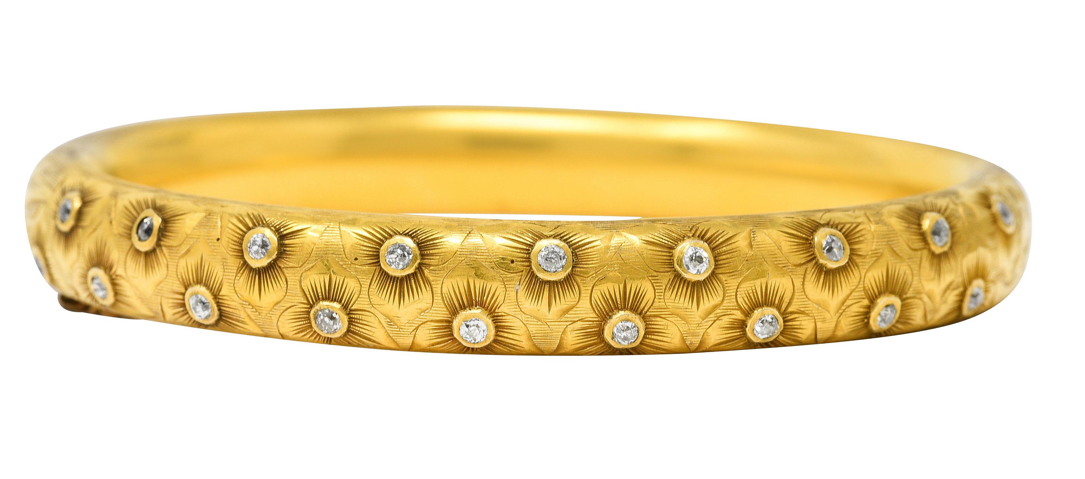 Der runde Armreif ist rundum mit einem fein gravierten floralen Trillium-Motiv versehen. Mit alten europäischen Diamanten im Lünettenschliff auf der Vorderseite. Mit einem Gesamtgewicht von etwa 0,54 Karat - die Qualität entspricht dem Schliff und