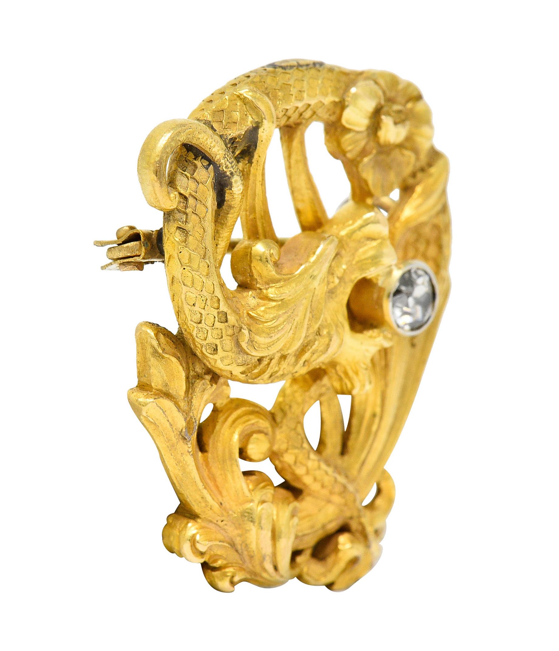 Designed as a serpentine dragon intertwined with whiplash and florals

Matte gold with highly rendered scales and herbaceous details

Clutching a bezel set old European cut diamond in its jaws

Weighing approximately 0.25 carat with J color with SI2