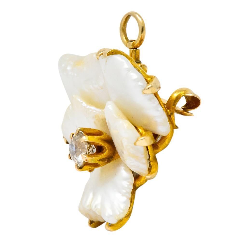 Brooch designed as a flower, centering a claw set old mine cut diamond weighing approximately 0.37 carat, K color and SI clarity

Surrounded by flat petal-like baroque pearls, with cream body color and very good luster

Claw set in matte gold frame