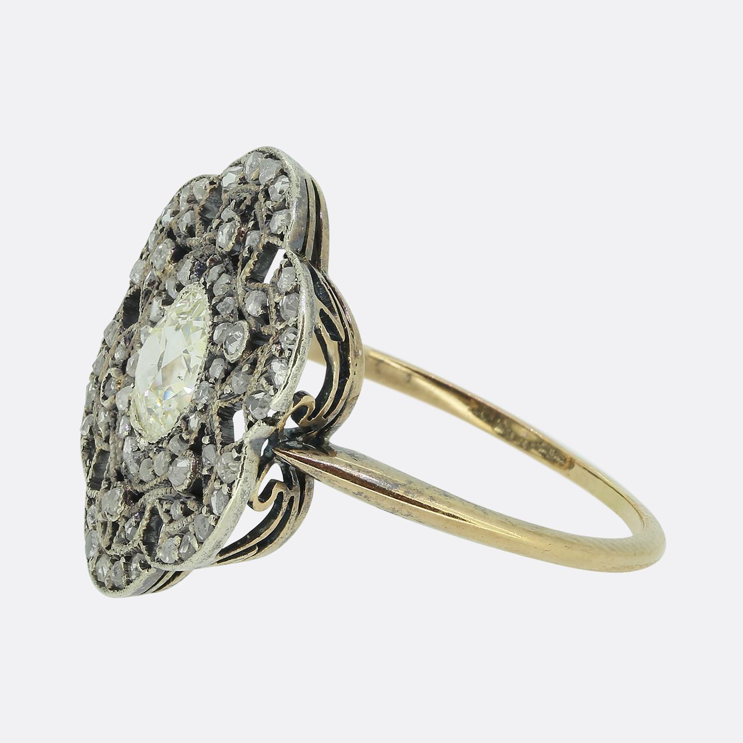 Hier haben wir einen charmanten Diamant-Cluster-Ring aus dem späten 19. Jahrhundert. Der Kopf dieses antiken Schmuckstücks wurde in eine geschwungene, sechseckige Form gebracht, die in der Mitte einen ovalen, facettierten Diamanten im Altschliff
