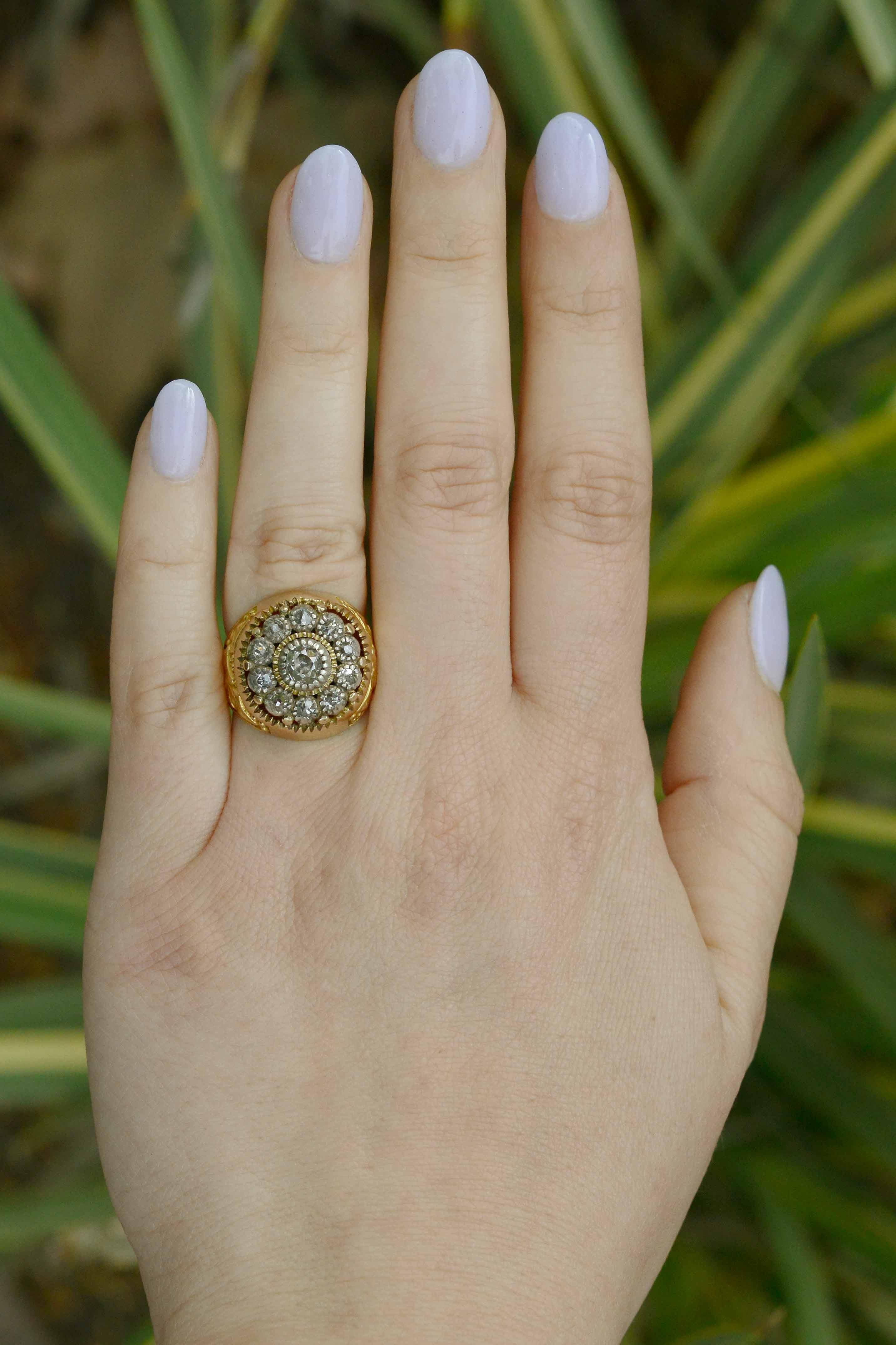 A chunky yet artful diamond cluster ring studded with 10 rose cut diamonds centering on an ever-so-stunning old mine cut diamond. This gorgeous cocktail ring is an antique treasure with the concurrent Art Nouveau era flare of the rich 18k gold