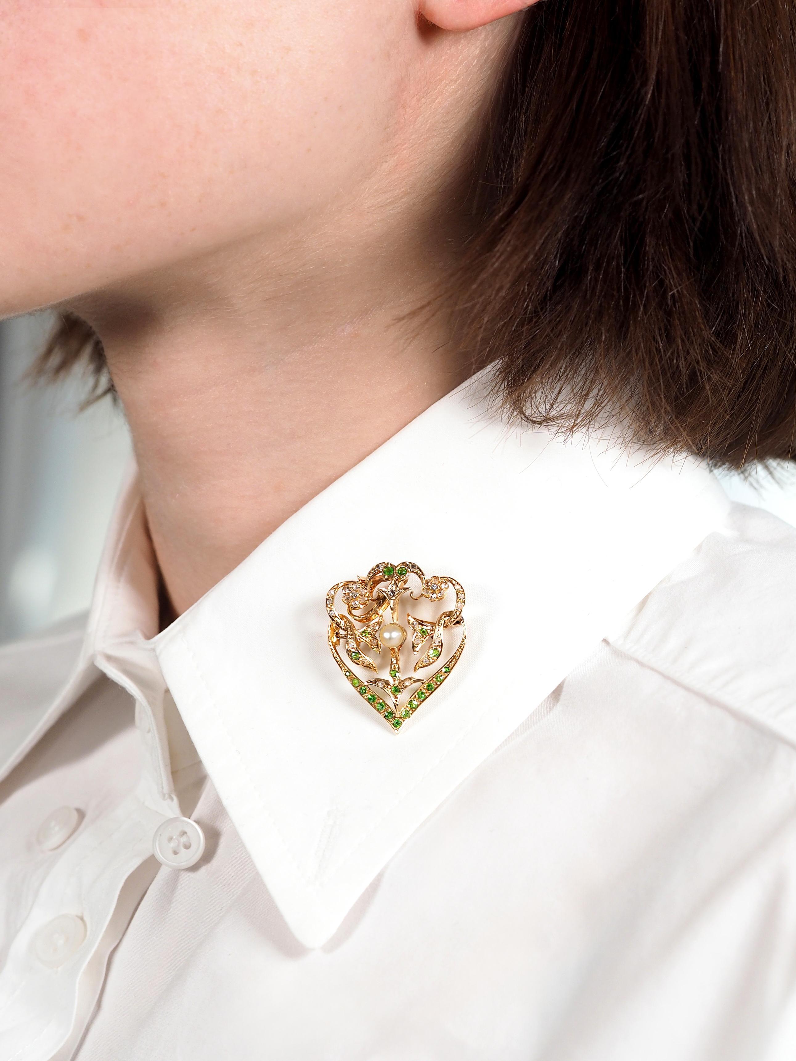 Designed as a lavalier style pendant with open work depicting whiplash foliates and flowers
Bead set throughout with rose cut diamonds and round cut demantoid garnets
Diamonds weigh approximately 0.44 carat total - quality consistent with