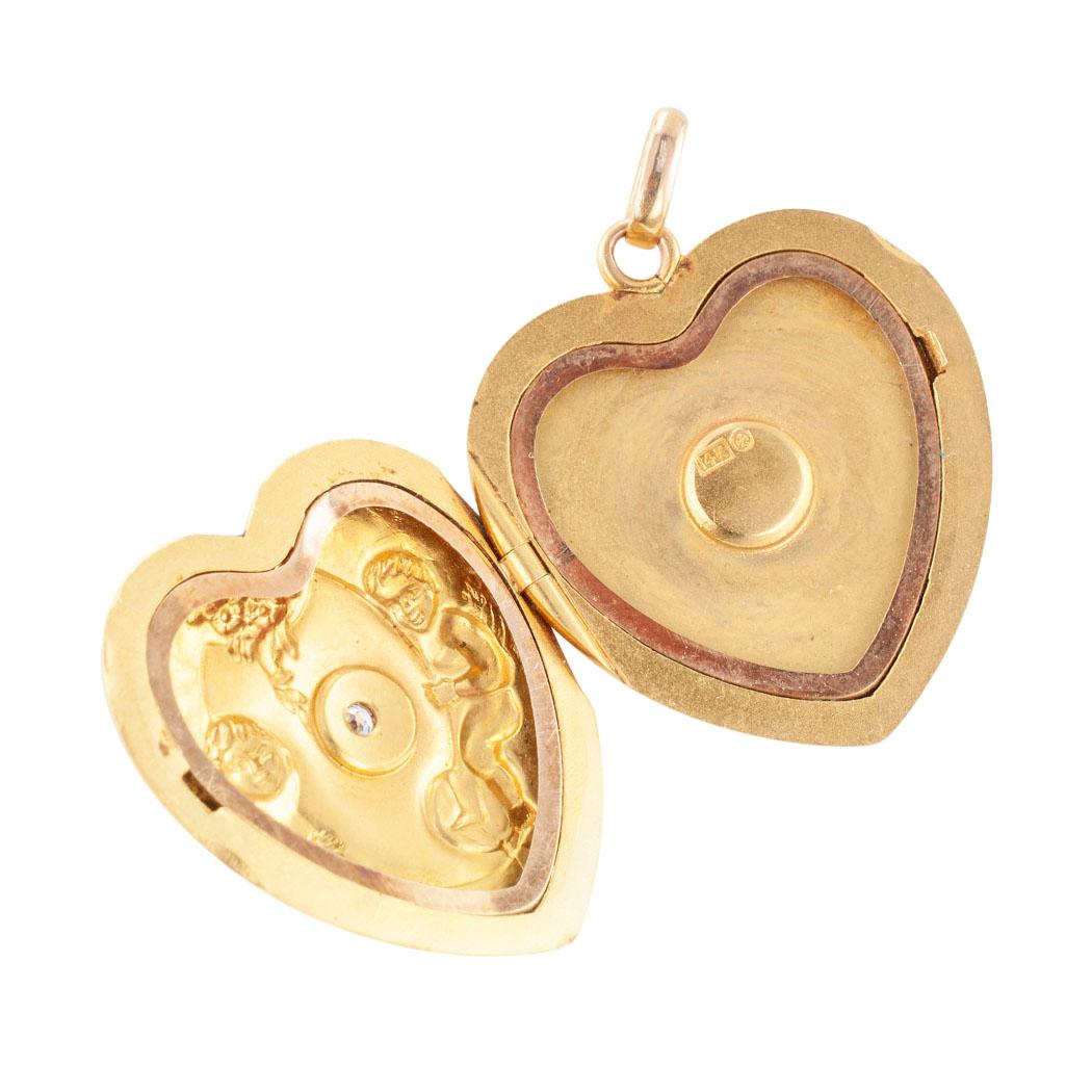 Art Nouveau diamond and gold heart shaped locket decorated by a pair of cherubs and floral motifs circa 1905.

DETAILS:
Art Nouveau heart-shaped gold locket centering upon a small round diamond within a shield motif embraced by a pair of cherubs and