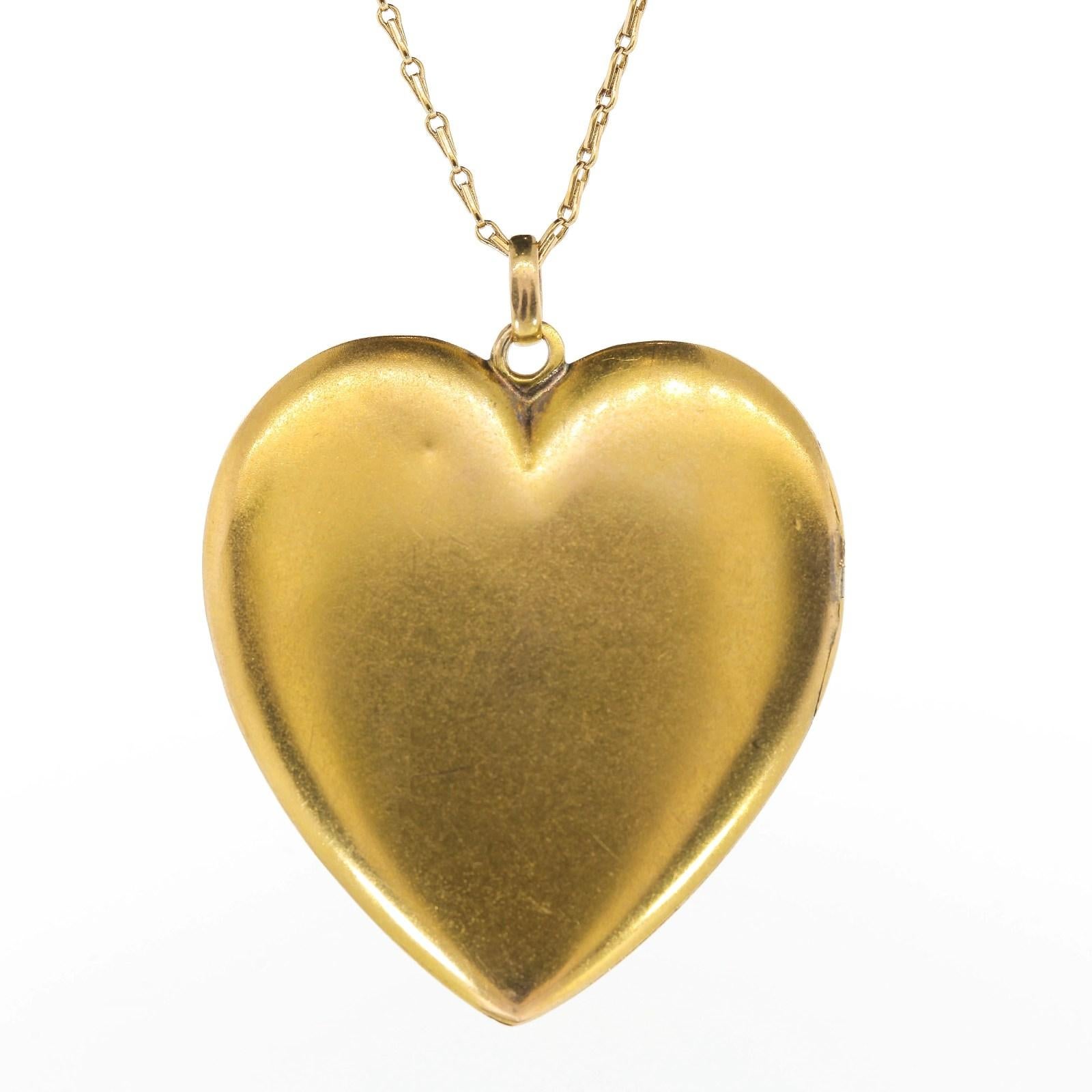 Understated beauty from circa 1900, this lovely locket created in 14KT yellow gold.  The heart locket is encrusted with nine Old Cut Diamonds placed in star settings, and it opens up to reveal two rose gold framed compartments; perfect to frame