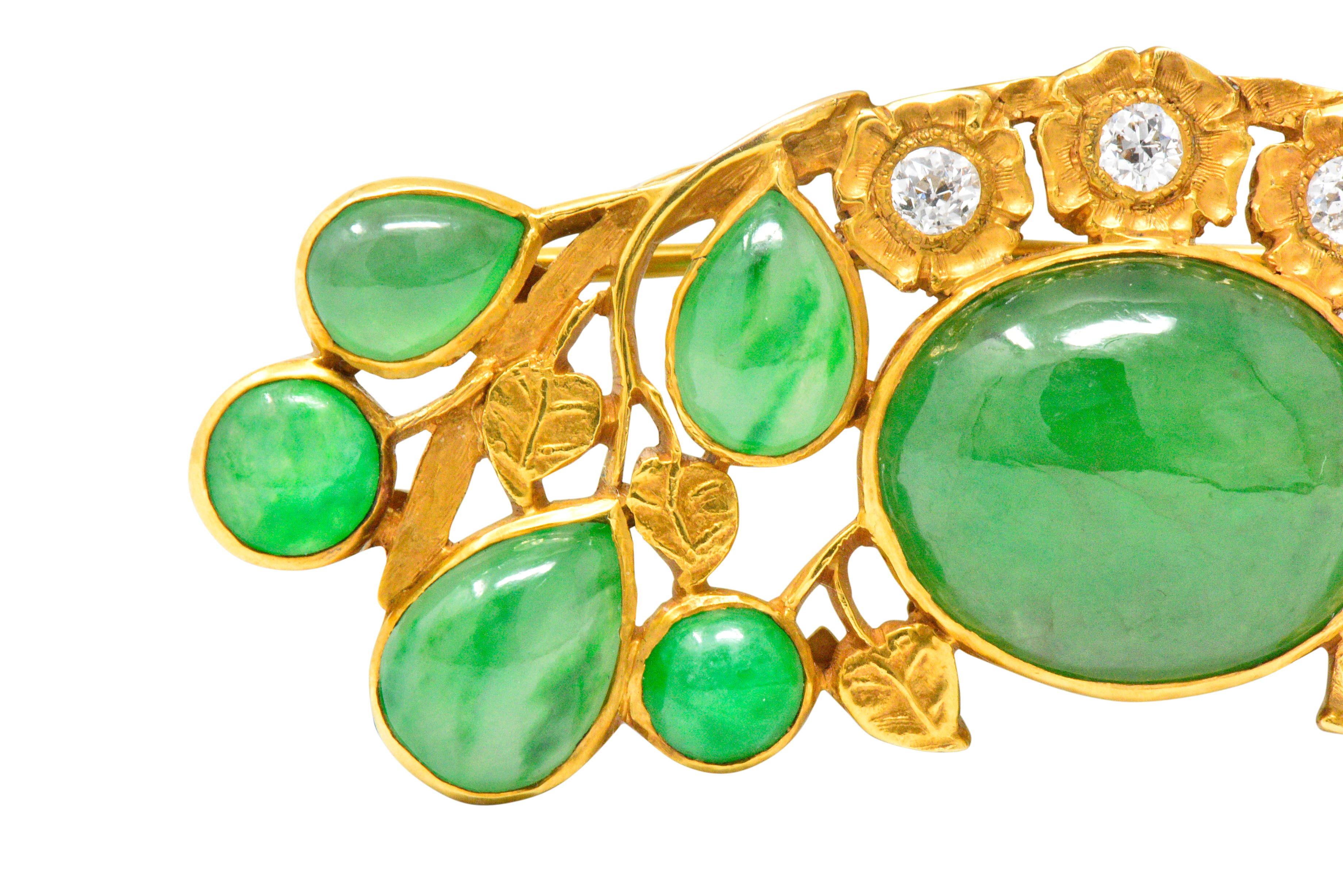Bar style brooch designed as winding vines with highly rendered florals and foliate

Centering a substantial bezel set oval double jadeite cabochon that measures 14.1 x 13.7 mm

Translucent green with some dark green veining, Type 
