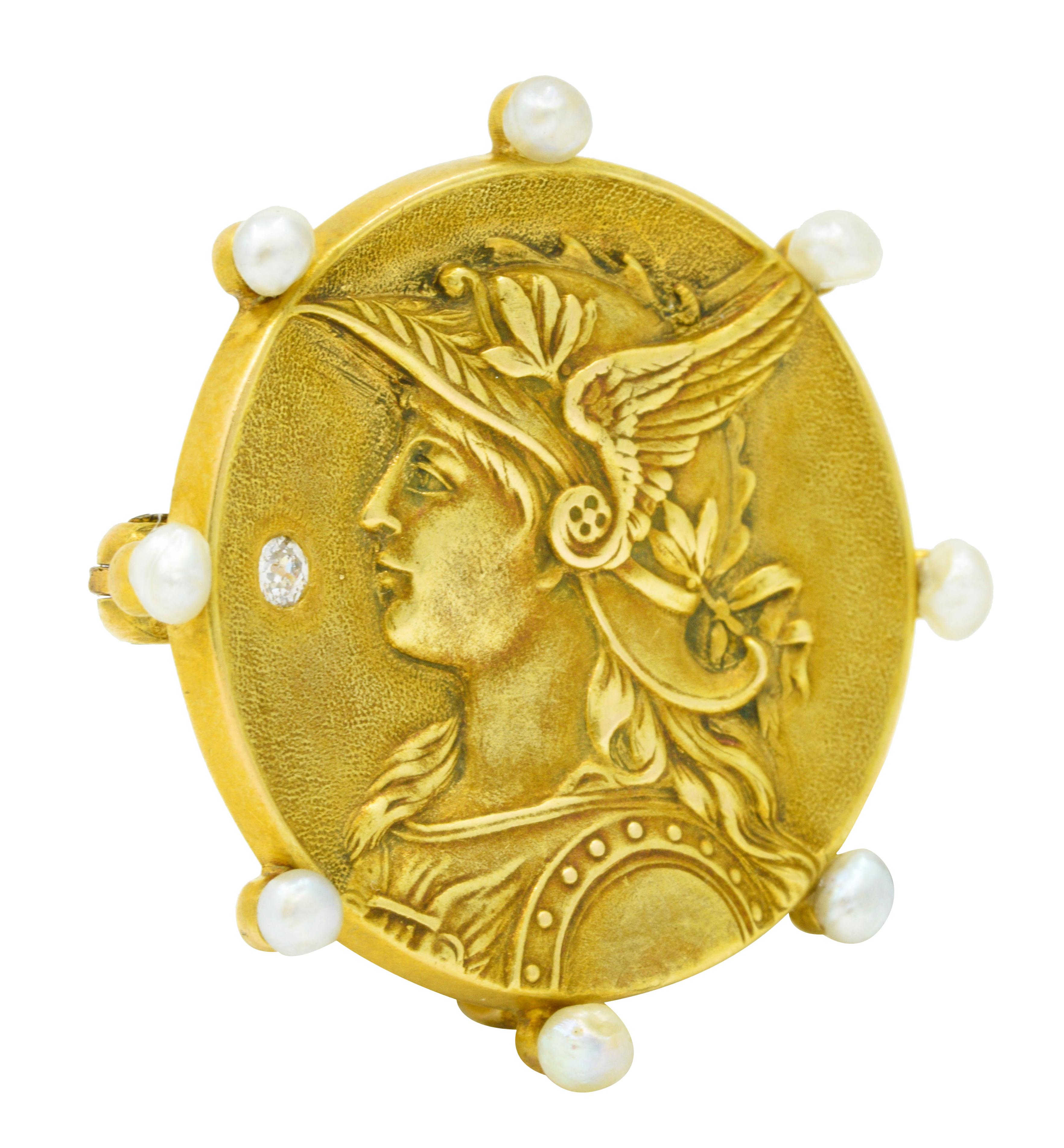 Circular brooch features a highly rendered depiction of Athena, goddess of wisdom and war

Accented by an old mine cut diamond weighing approximately 0.04 carat - eye clean and white

Surrounded by 2.5 mm semi round pearls - white in body color with