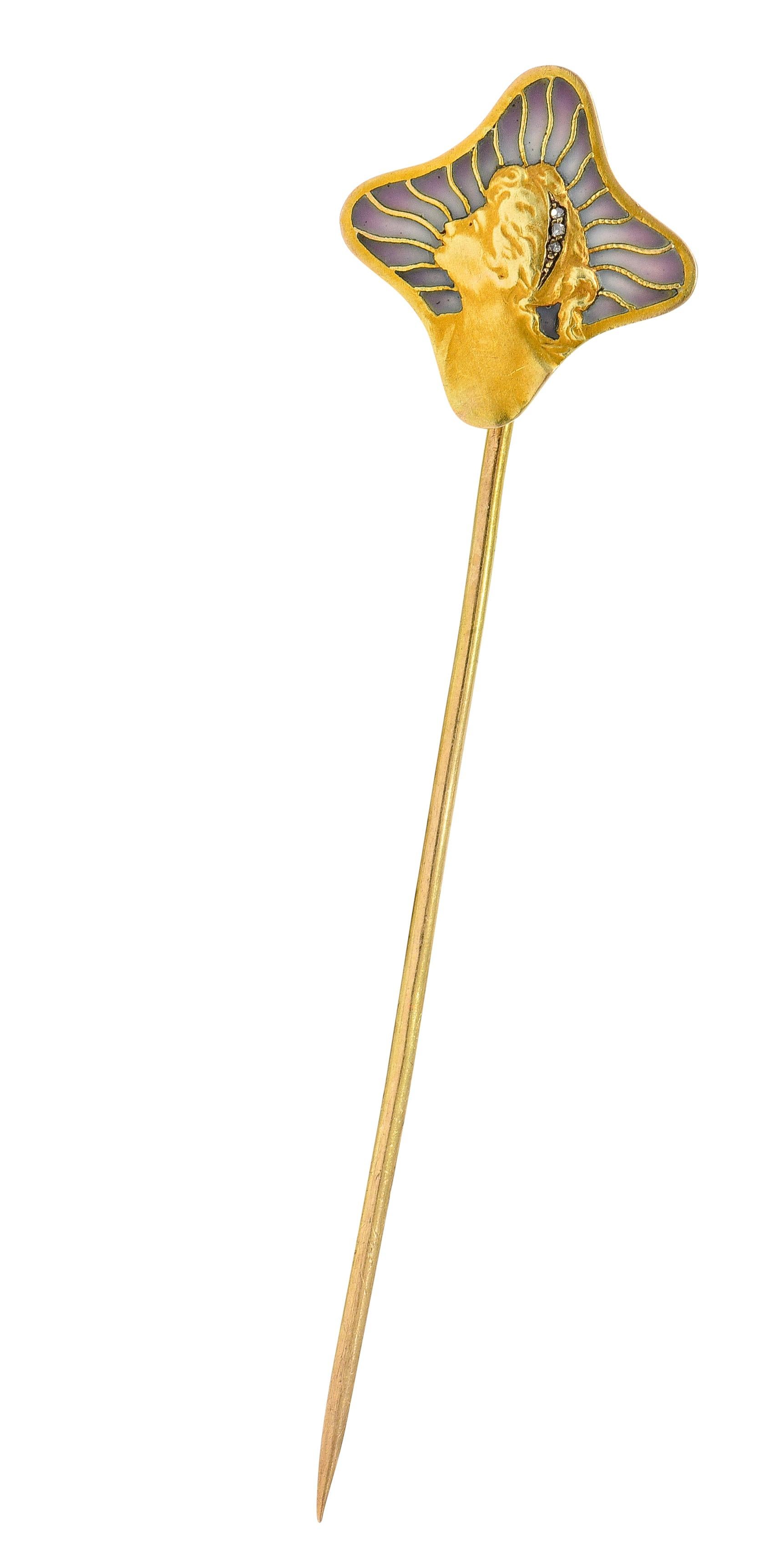 Stickpin has a quatrefoil shaped head and depicts the matte gold profile of a Gibson Girl

Highly rendered with tousled tresses accented by rose cut diamonds

With a radiated background design glossed with translucent plique-a-jour enamel

Ombrè