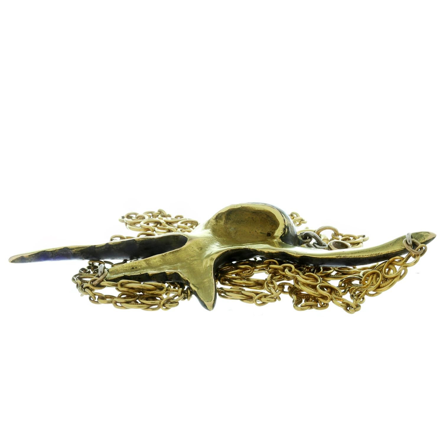 This rare and collectible antique Art Nouveau necklace features a pendant of swallow bird with outstretched wings in flight crafted in platinum and 15k yellow gold and plique-à-jour enamel and accented with red ruby eyes and completed with a