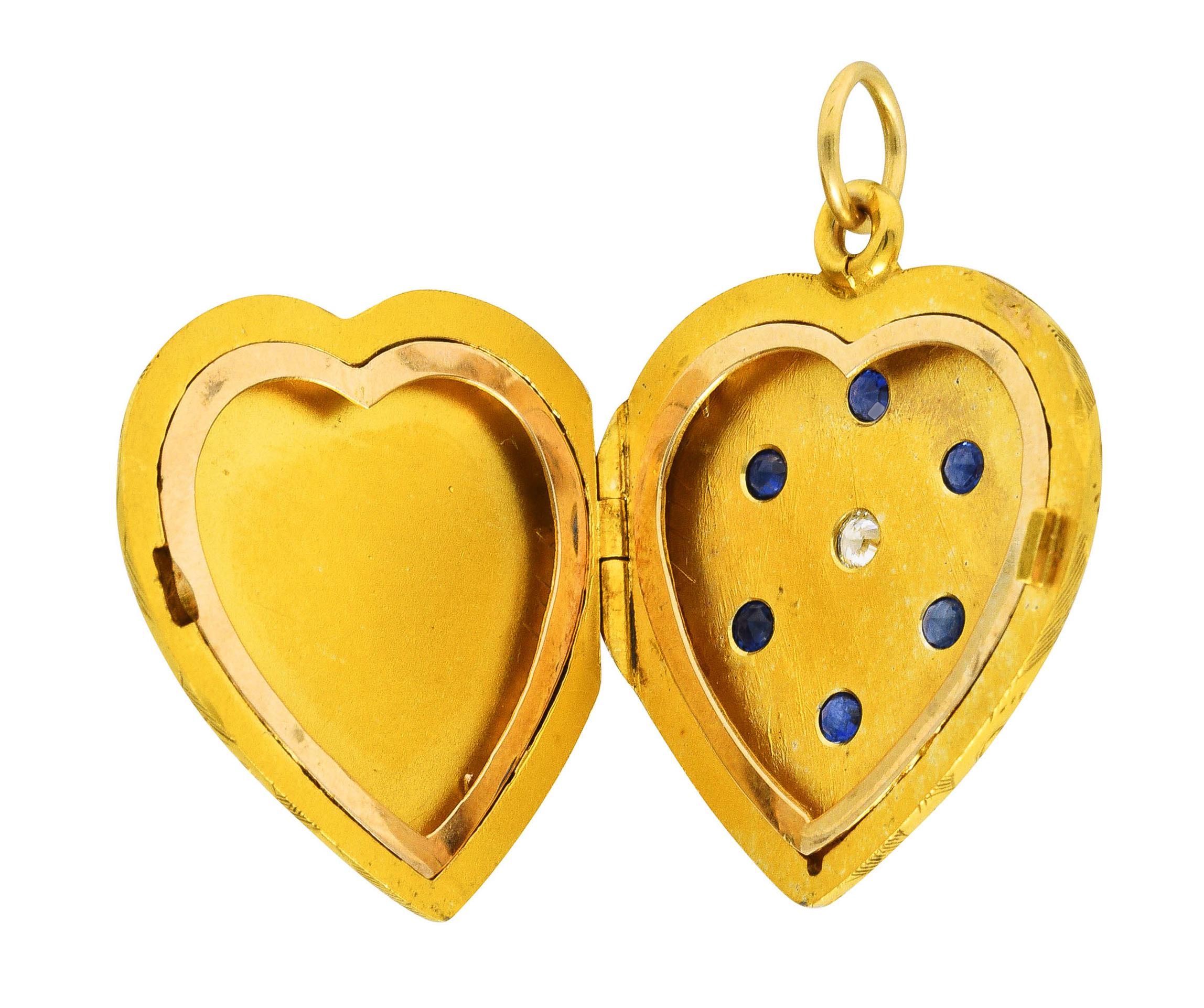 Pendant is designed as a heart shape centering a flush set old European cut diamond

Weighing approximately 0.10 carat total - eye clean and bright

Featuring a surround of six flush set round sapphires

Weighing approximately 0.55 carat total -