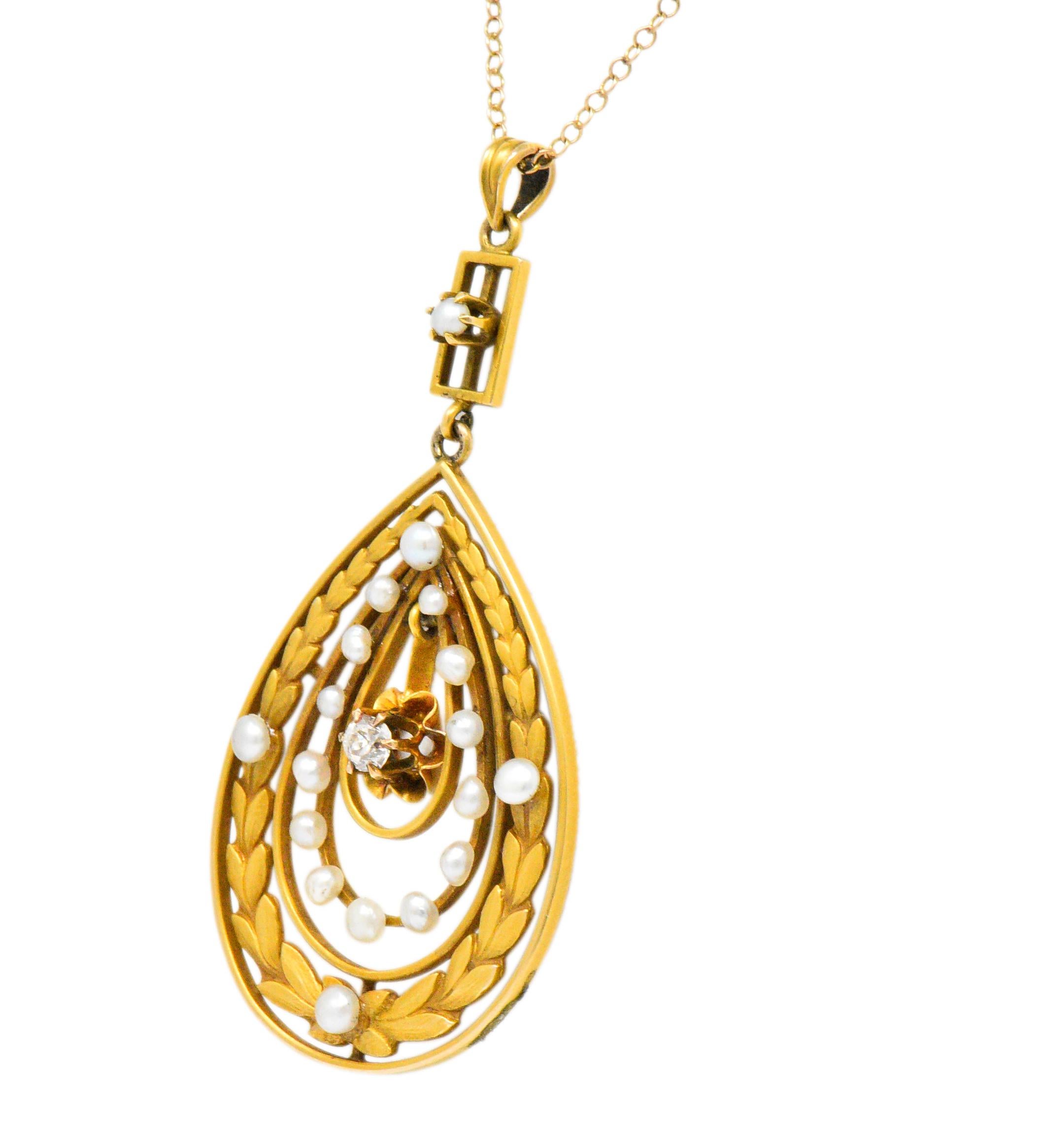 Open drop motif centering an articulated belcher set old mine cut diamond weighing approximately 0.15 carat; eye-clean and white

Surrounded by a matte gold foliate motif and accented throughout by seed pearls

Accompanied by a cable style chain