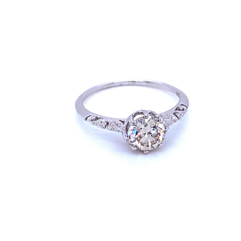 Simply and classy, this elegant Art Nouveau solitaire ring, is handcrafted in solid 18k white gold and it is set with one sparkling Old mine cut Diamond, weighing 0,90 carat and graded H color Vs1. 
The low-profile engraving of the mount make this