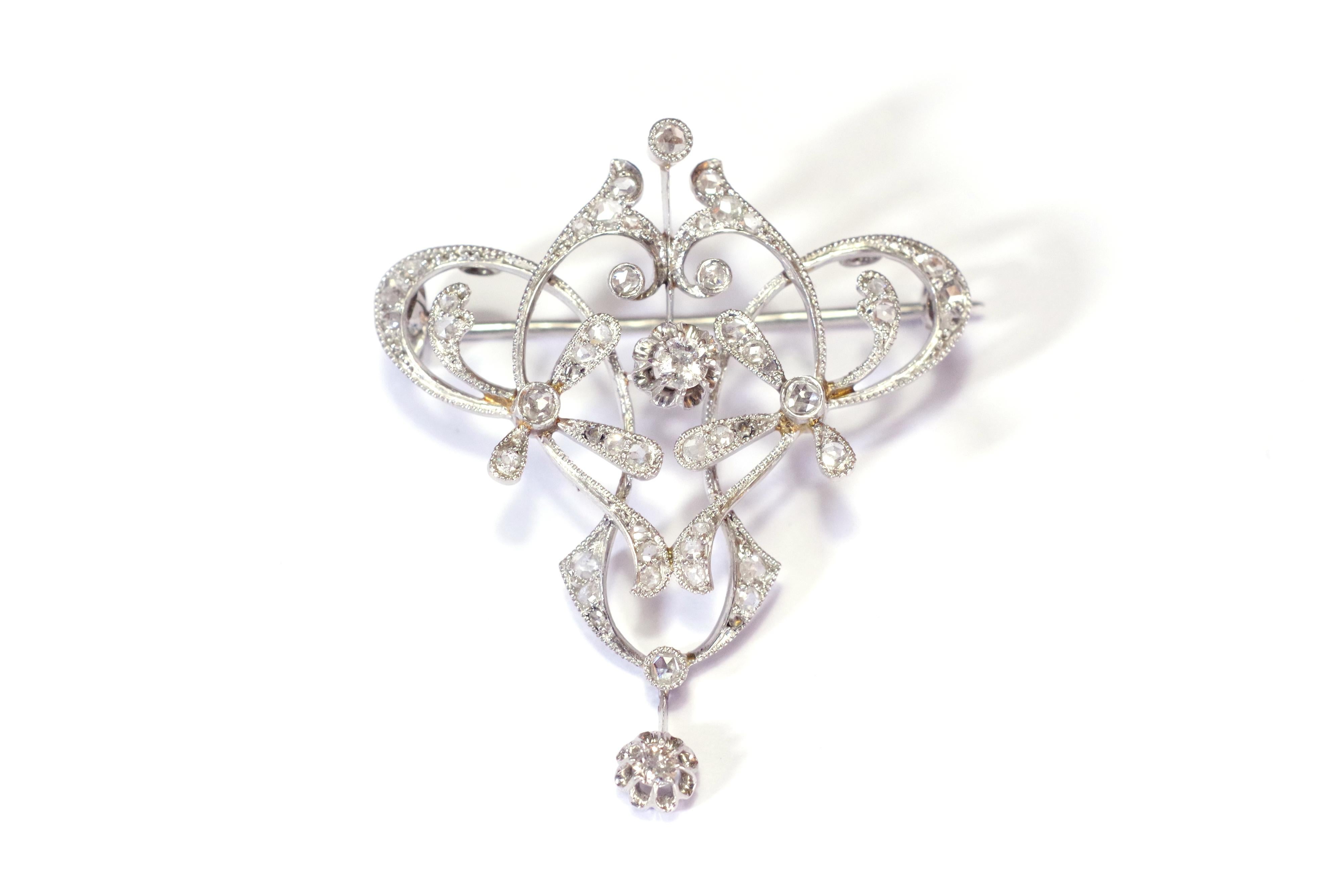 Art Nouveau diamonds brooch pendant in platinum (950/1000). Brooch or pendant of triangular form with stylized floral design, entirely openwork. The jewel is decorated with fifty-one diamonds of which forty-nine are rosecut and two in brilliant.