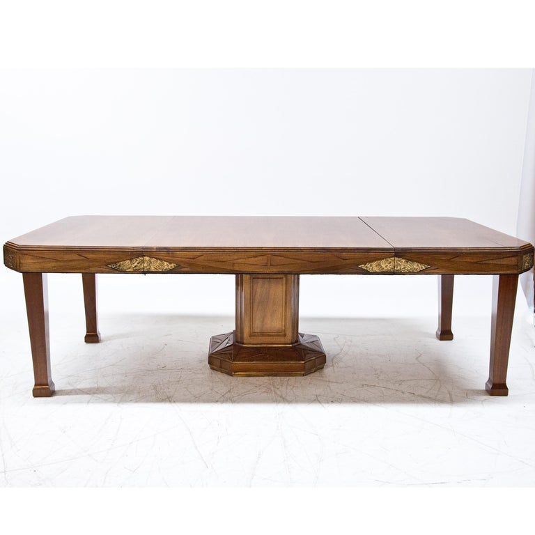 Table standing on octagonal column base with extendable tabletop (up to 250 cm). The sides and base are decorated with geometrically carvings. The frame is additionally decorated with gold patinated panels with fruit ornaments.
        