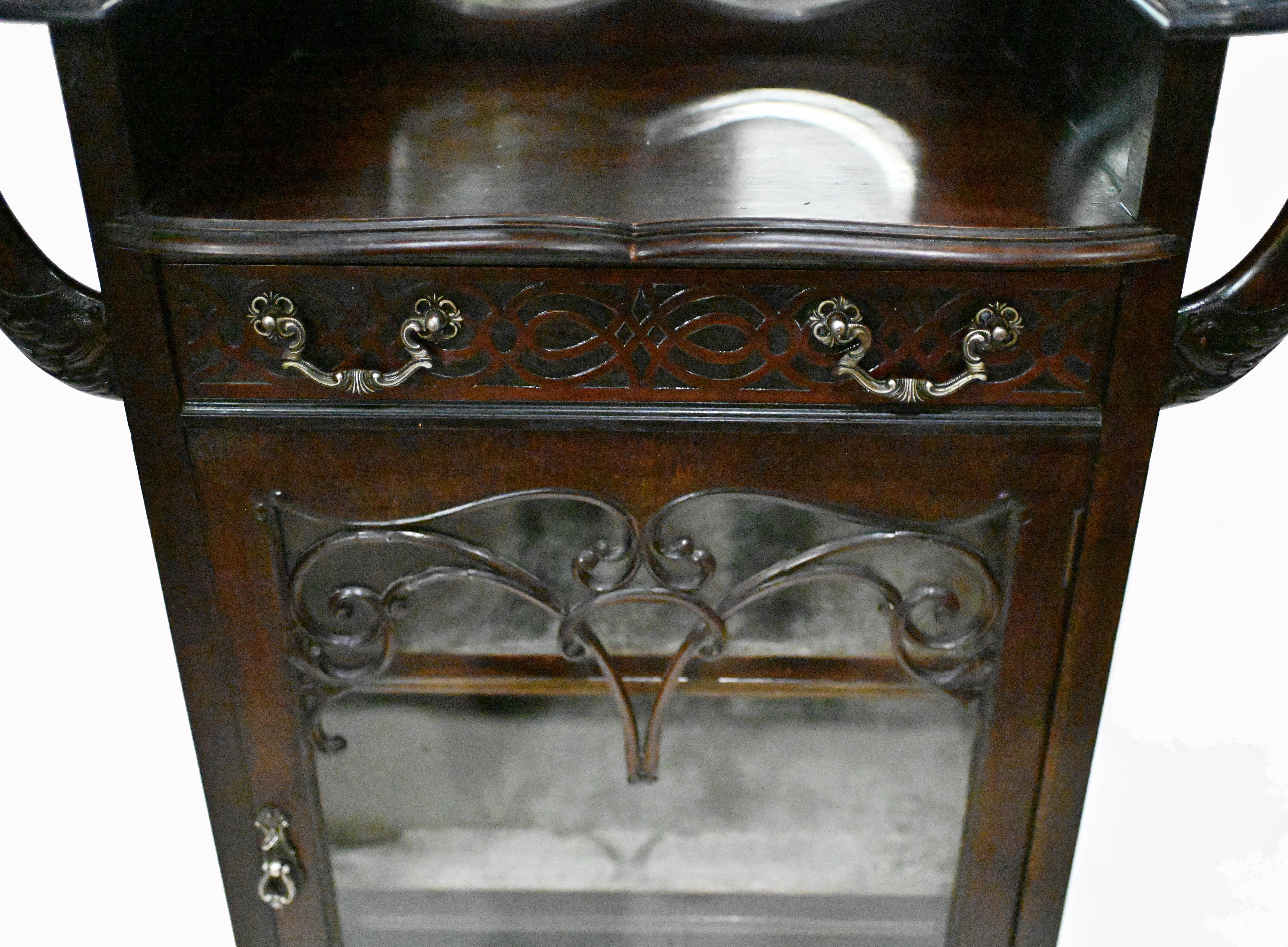 You are viewing a stylish art nouveau display or drinks cocktail cabinet
Very ornate piece, especially the floral motifs on the back piece
Drawer features intricate fret works also and the drink serving area has a mirror behind it
We date this