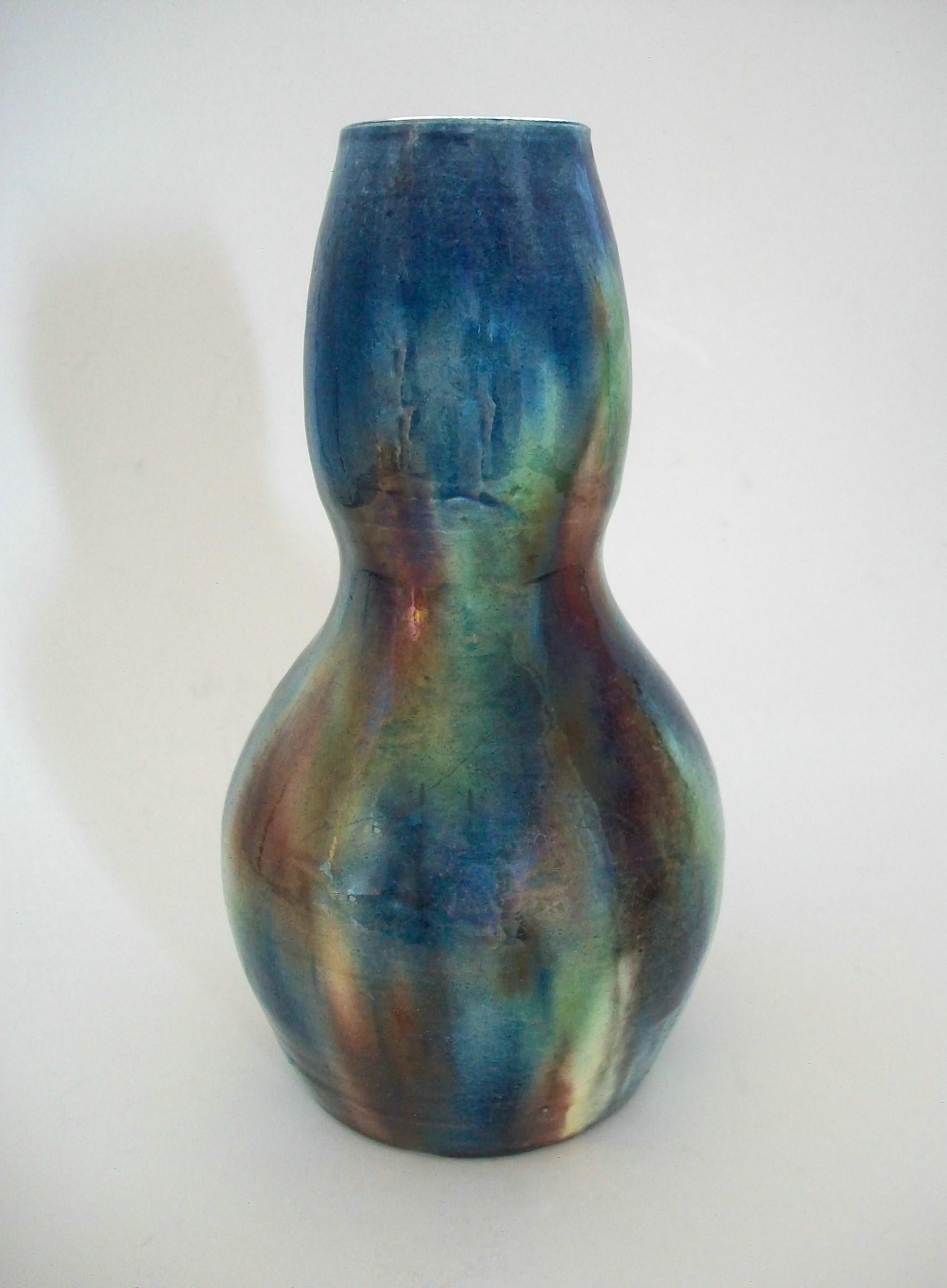 Art Nouveau double gourd studio pottery vase - featuring multi-color splashed glazes with an iridescent finish - all on a cream ceramic ground - wheel thrown - unsigned - inscribed C to the base - Belgium - early 20th century.

Excellent antique