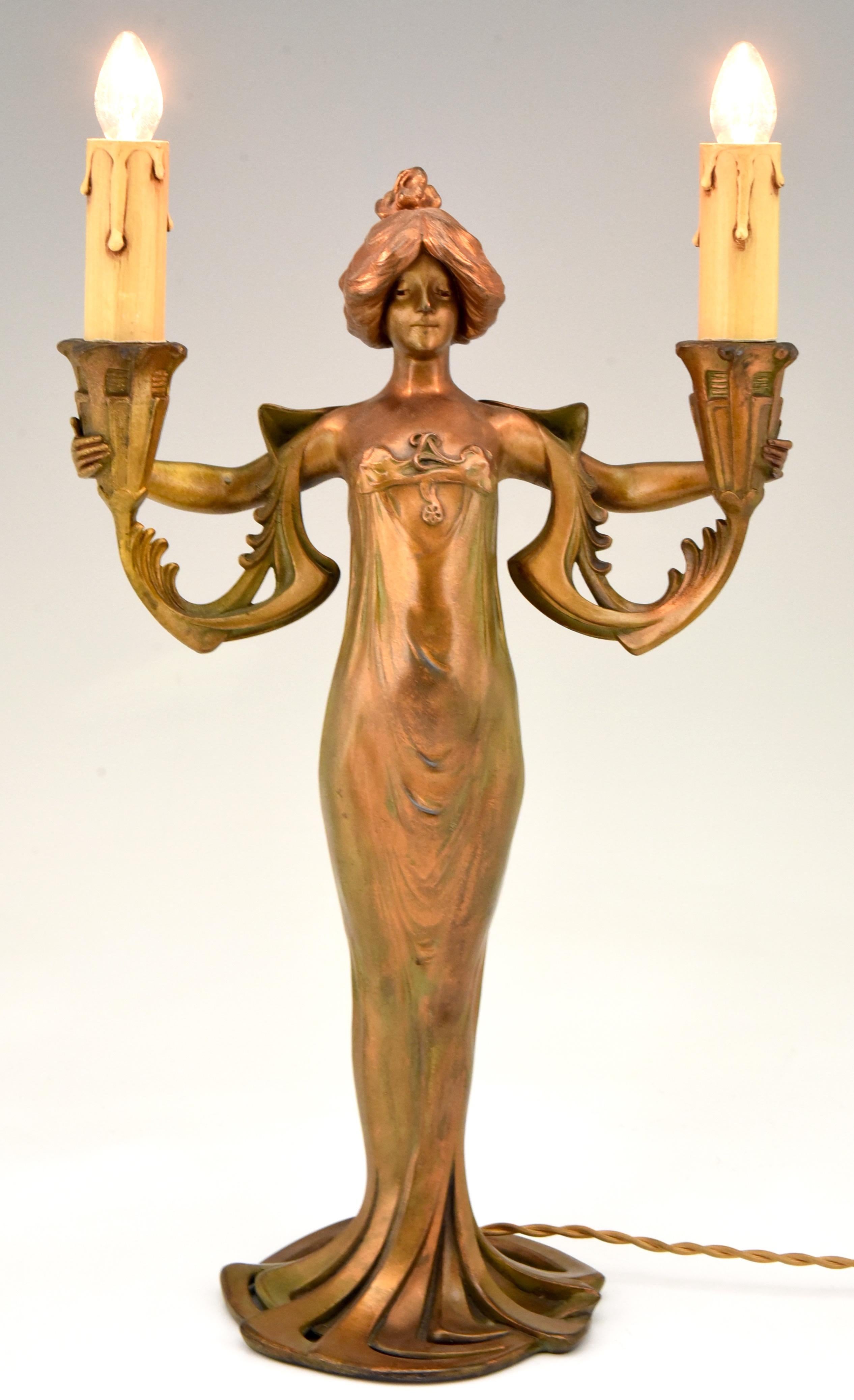 Art Nouveau figural lamp lady in long dress holding two candles by Lucien Alliot.
Patinated Art metal.
France, 1900. 

Literature:
“The dictionary of sculptors in bronze” by James Mackay.? Antique collectors club.? “Les bronzes de XIXe siècle”