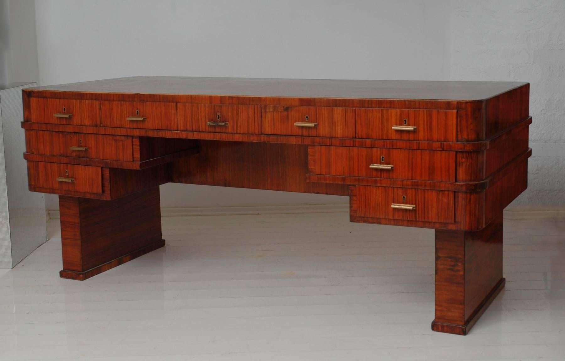 Dieser seltene große doppelseitige Schreibtisch wurde von Lajos (Ludwig) Kozma entworfen, der durch seine Zeichnungen, Gebäude und Möbel einen beispiellosen Einfluss auf das europäische Design hatte.

Dieser Schreibtisch ist mit Walnuss- und