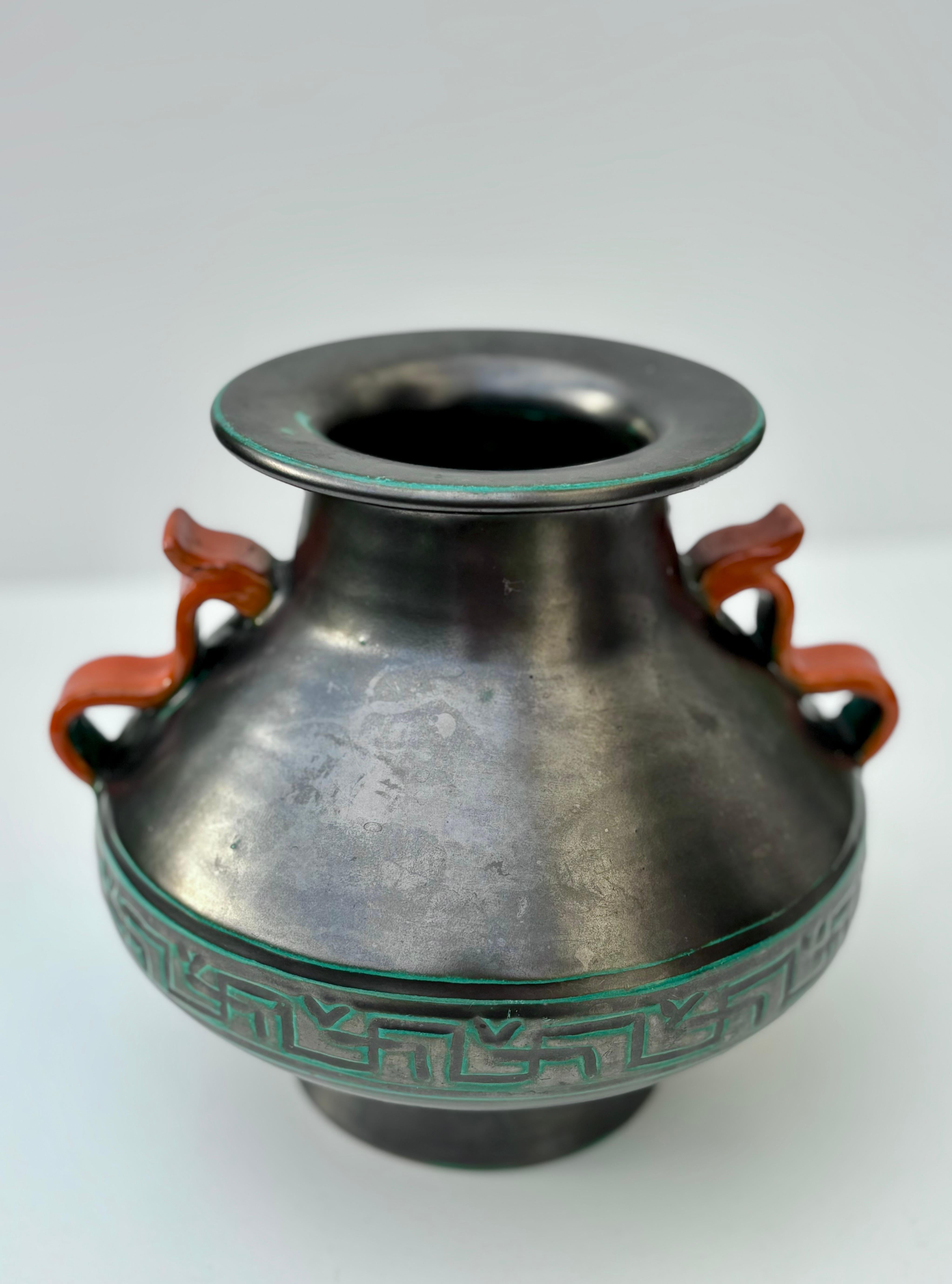 Dark gray modern art nouveau vase by Upsala Ekeby in the 1940s. Soft shaped ceramic vase with a mother of pearl like shine, green accents, geometric belt around the belly and two orange red handles.
Stamped and numbered under base. 
Beautiful