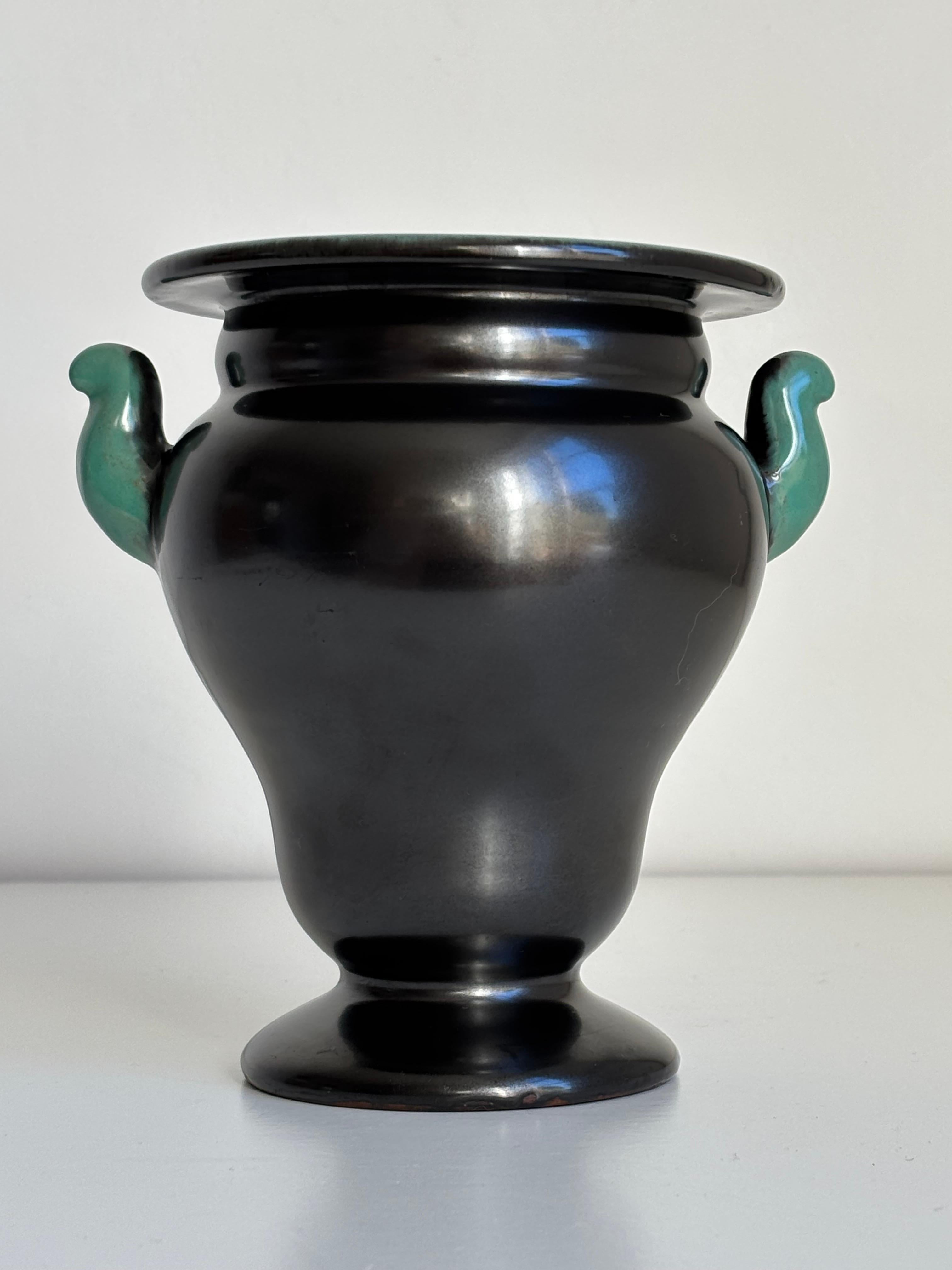 Black art nouveau vase by Upsala Ekeby manufactured in the 1940s. Soft shaped ceramic vase with a mother of pearl like black shine, sea foam green flared top edge and small ear-like handles.
Stamped and numbered under base. 
Beautiful vintage