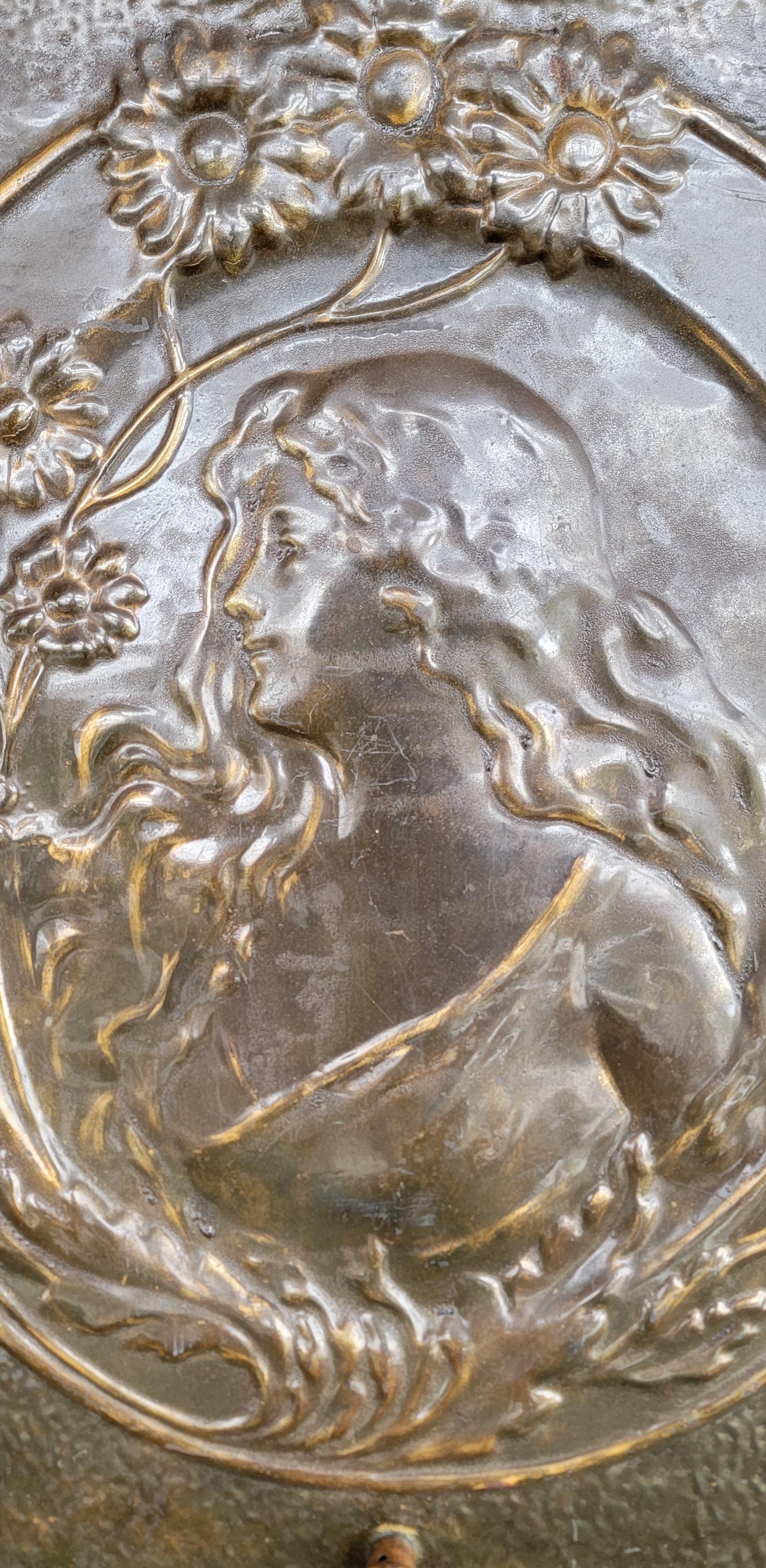 Art Nouveau stove or fire screen featuring classic female with flowing hair. Has been up-cycled to a decorative piece of wall art. Made of pressed steel with a brass patina. Circa. 1895-1915. 

25.75 inches high.
19.75 inches wide.
2.75 inches deep.
