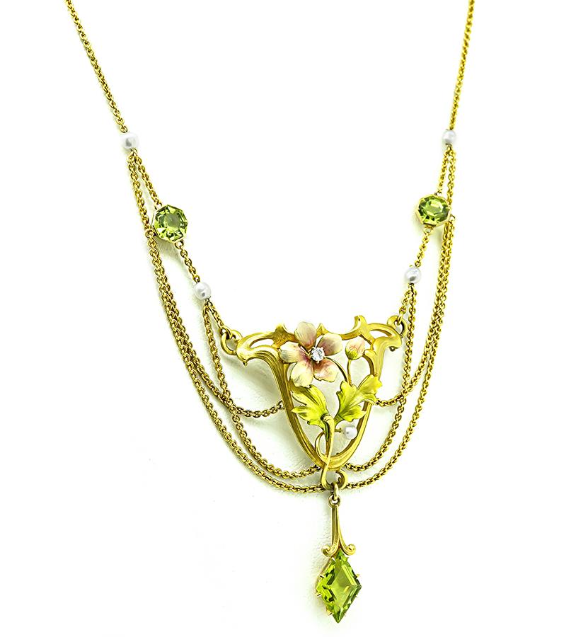 Questa è una splendida collana in oro giallo 14k dell'epoca Art Nouveau. Lo smalto presenta deliziosi accenti di peridoto e intarsi di smalto. Il ciondolo misura 60 mm per 35 mm. La collana misura 16 3/4 pollici di lunghezza e pesa 15,9 grammi.