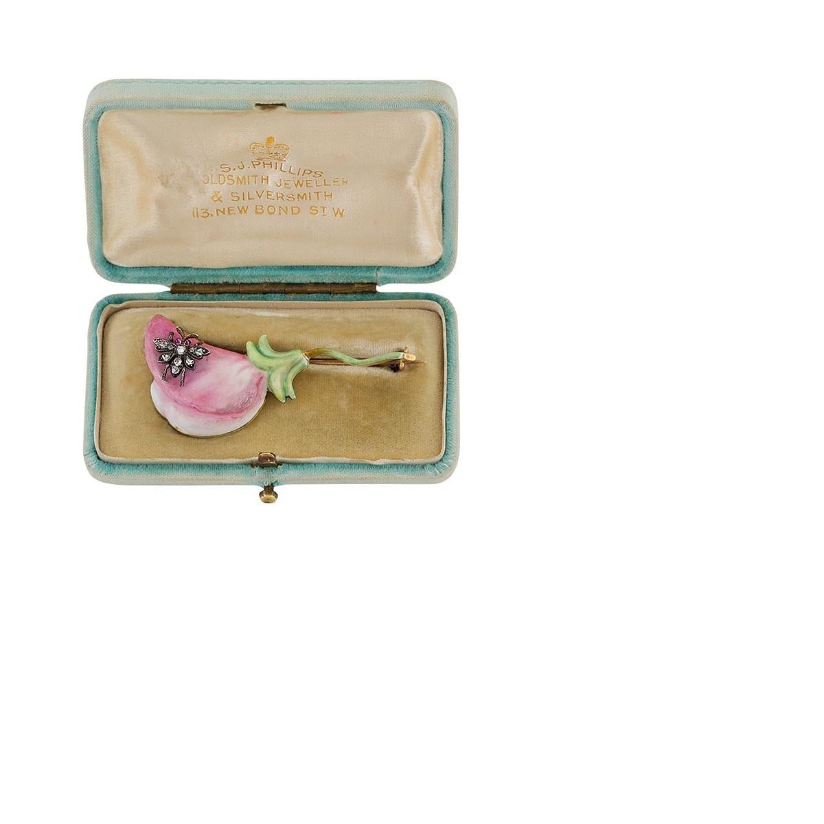 An Art Nouveau 18 karat gold sweet pea brooch in pink and green shaded enamel. On the open petal of the charming pink bloom is a silver-topped gold insect studded with 14 rose-cut diamonds weighing 15 carat and 2 cabochon ruby eyes that weigh .04