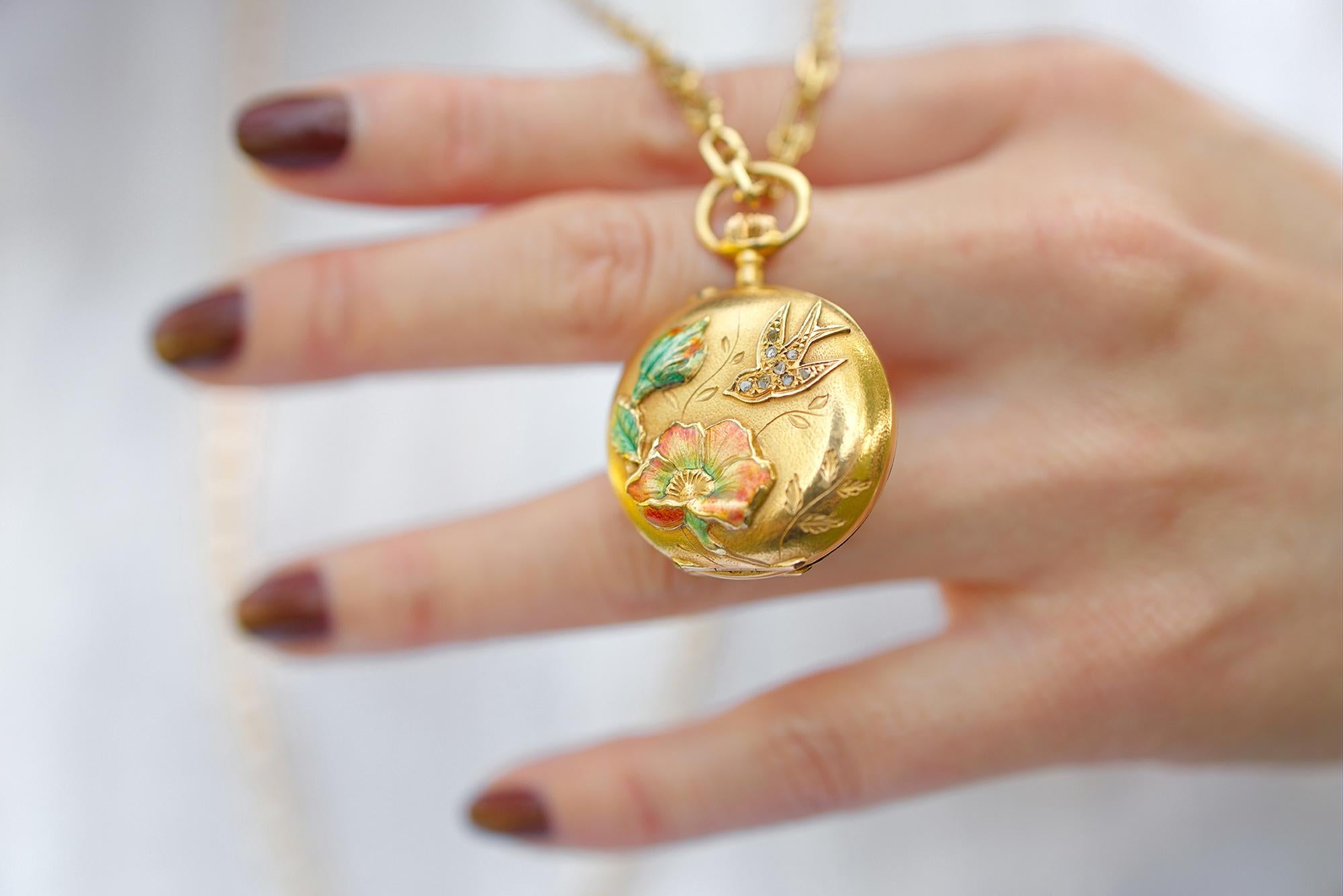 For sale a beautiful French work, Art Nouveau era, pocket watch pendant with one swallow and enameled lily flower with its leaves. The swallow is set with 8 diamonds in rose cut style, and the floral motifs are enameled in green, red and gold with