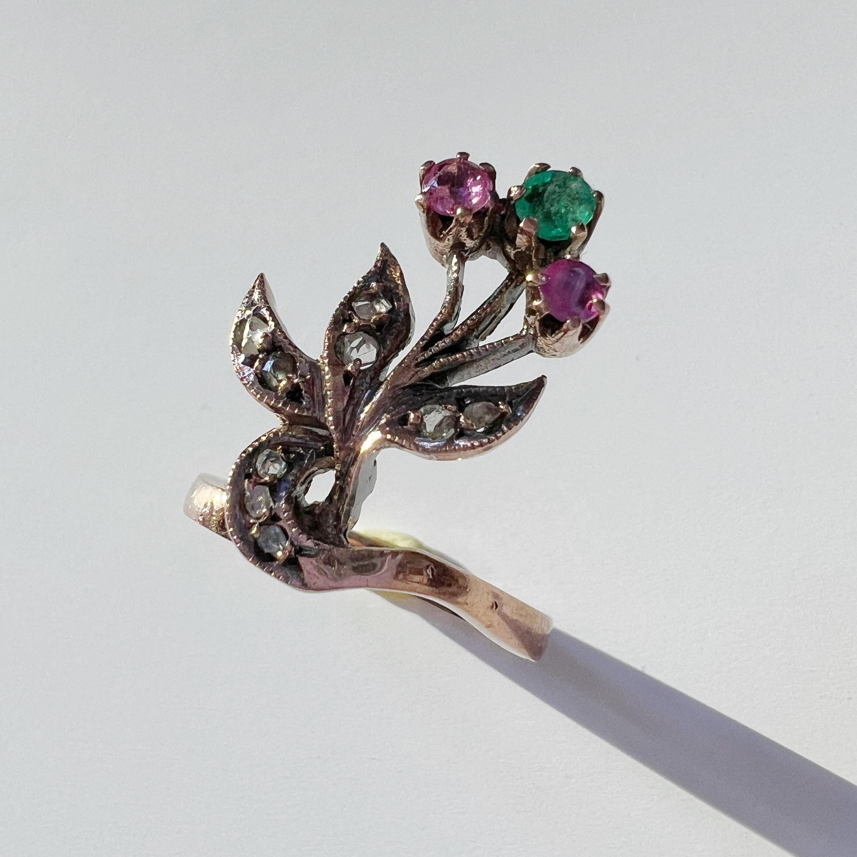 Zum Verkauf steht ein antiker 9K Goldring aus der Zeit des Jugendstils. Dieser Ring zeigt ein süßes Blumenbouquet, das aus einem facettierten Smaragd und zwei bezaubernden facettierten Rubinen gefertigt ist.

Die zarten Blätter dieser botanischen