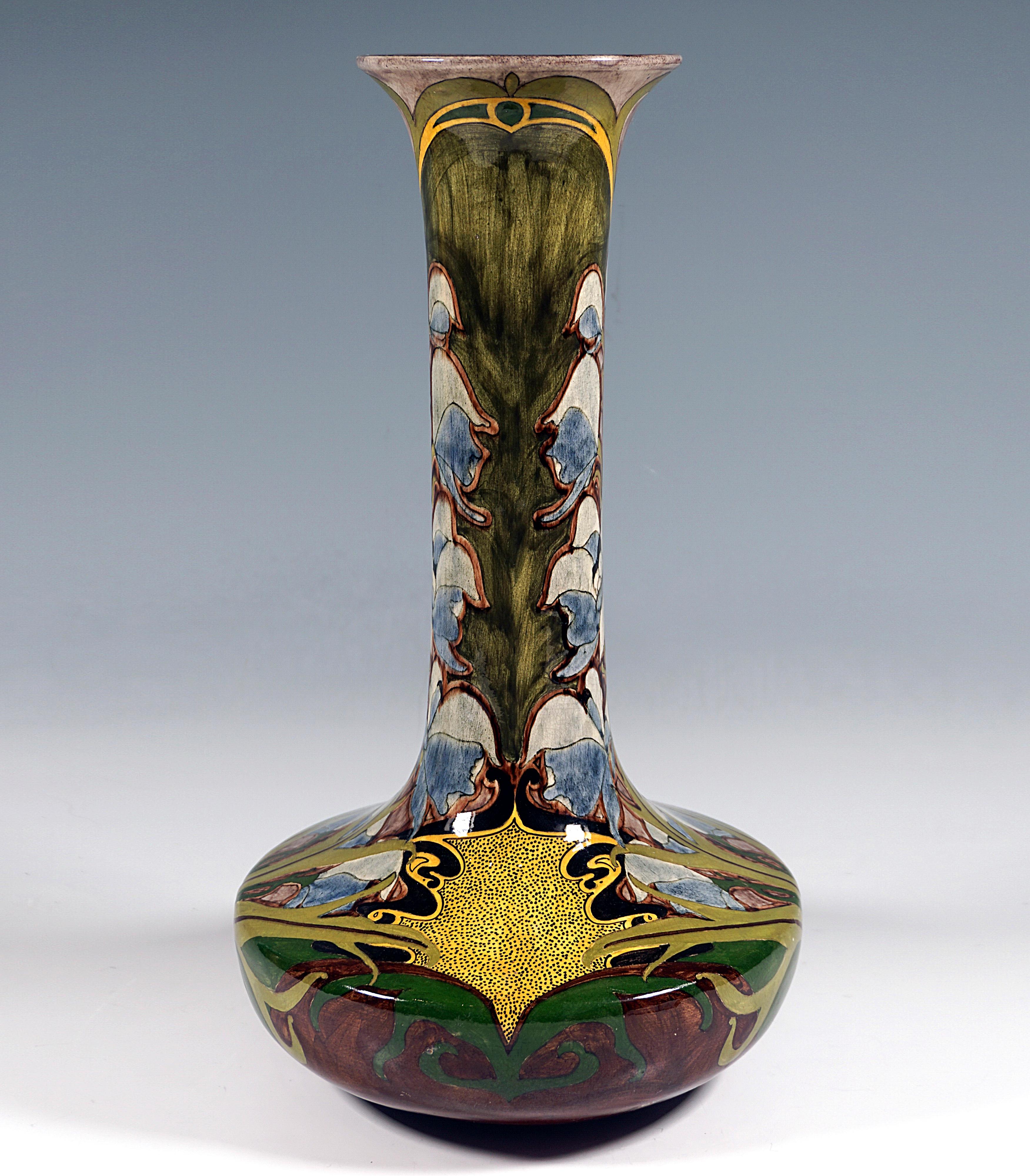 Excellent and decorative large faience long-necked vase, protruding bulbous body on a flush stand, tall cylindrical neck with flared mouth opening, largescale floral decoration in shades of green, brown and yellow with light blue aconite panicles,