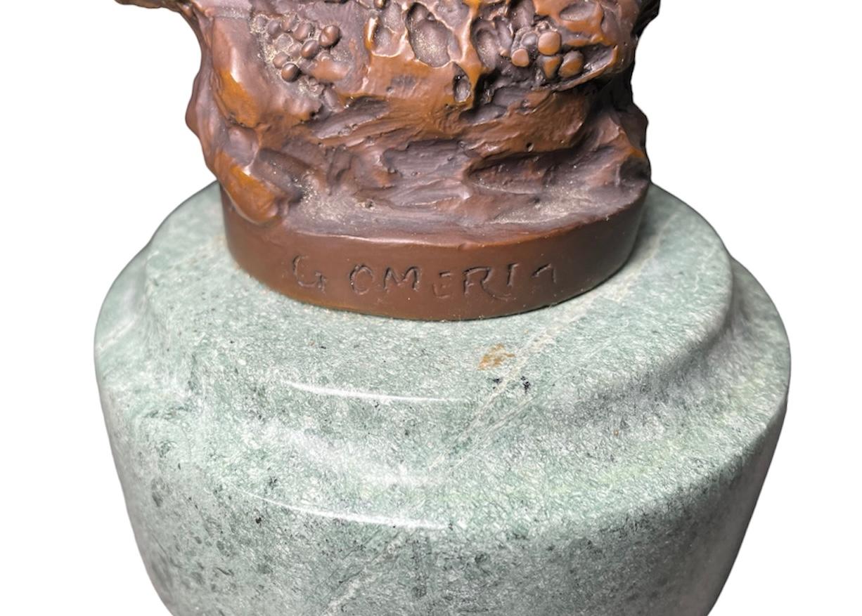 Questa è una scultura in bronzo di Donna Fauno. Raffigura una donna nuda e faunistica con zampe di capra che è sdraiata su una corona di fiori fatta di rami di vite e con una mano che la tiene. La scultura è sostenuta da una base rotonda in bronzo 