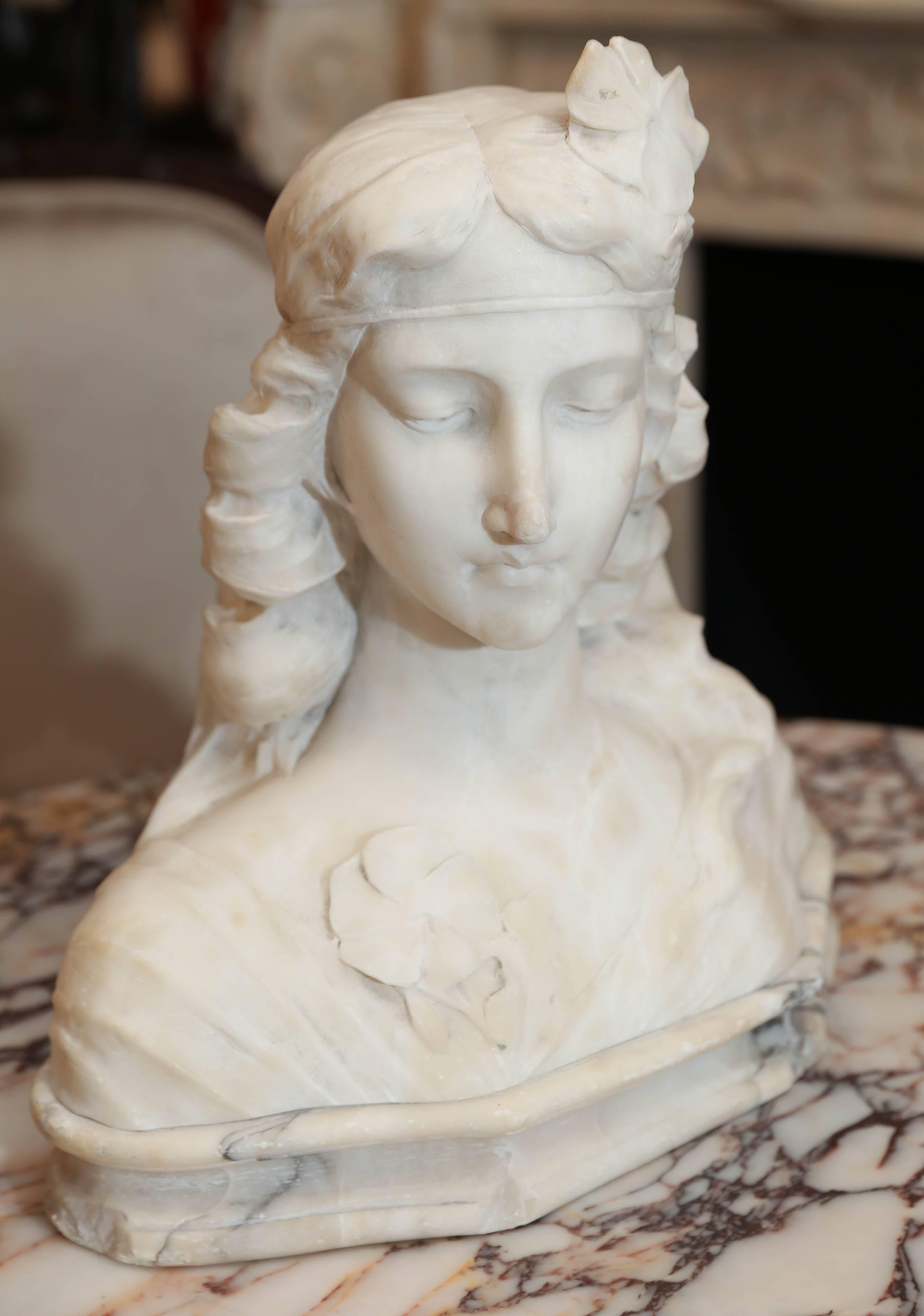 Beautifully carved bust in white Carrara marble. Female with
flowing hair and head band with a flower tucked in the
band.