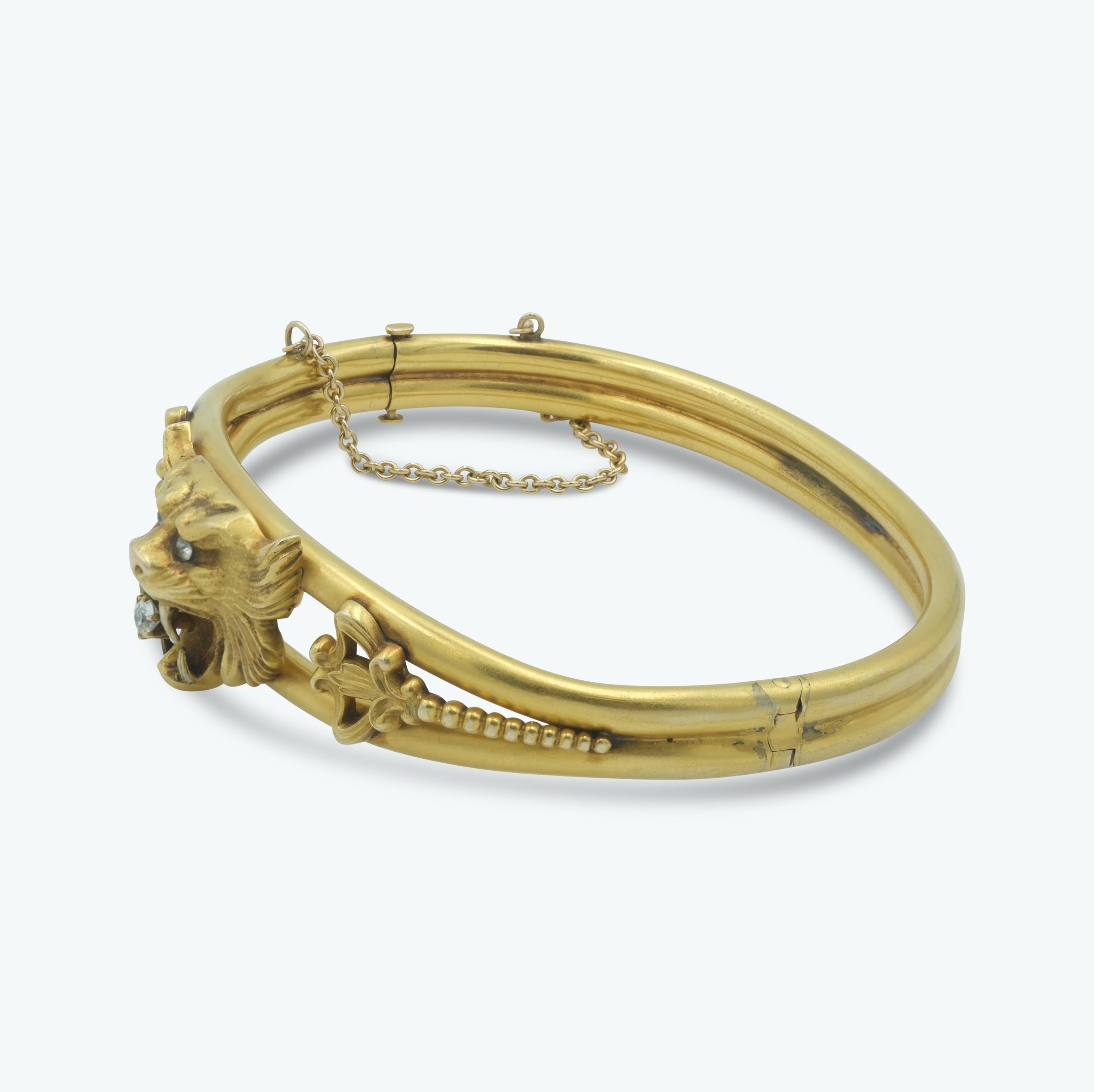 This Victorian 14 karat gold bangle is a stunning example of mid 19th-century craftsmanship. Featuring an intricate lion's head motif at its center, the bangle is accented with 0.16ct of diamond accents in the eyes and mouth, adding a touch of