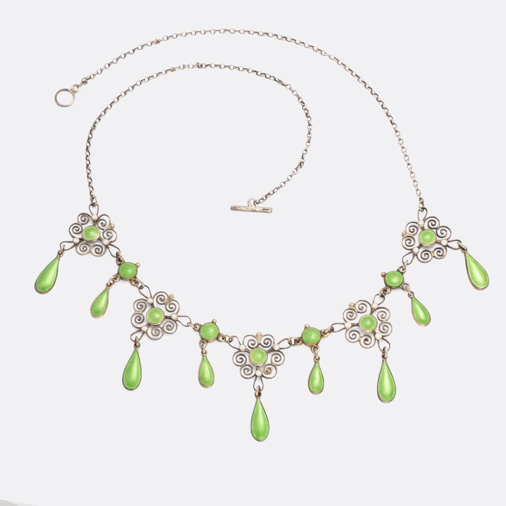 An Art Nouveau filigree necklace by Norwegian jeweller Marius Hammer. It was made around the turn of the 20th Century, featuring swirling ropework filigree along with green and white enamel drops - a tasteful combination of smooth and guilloché