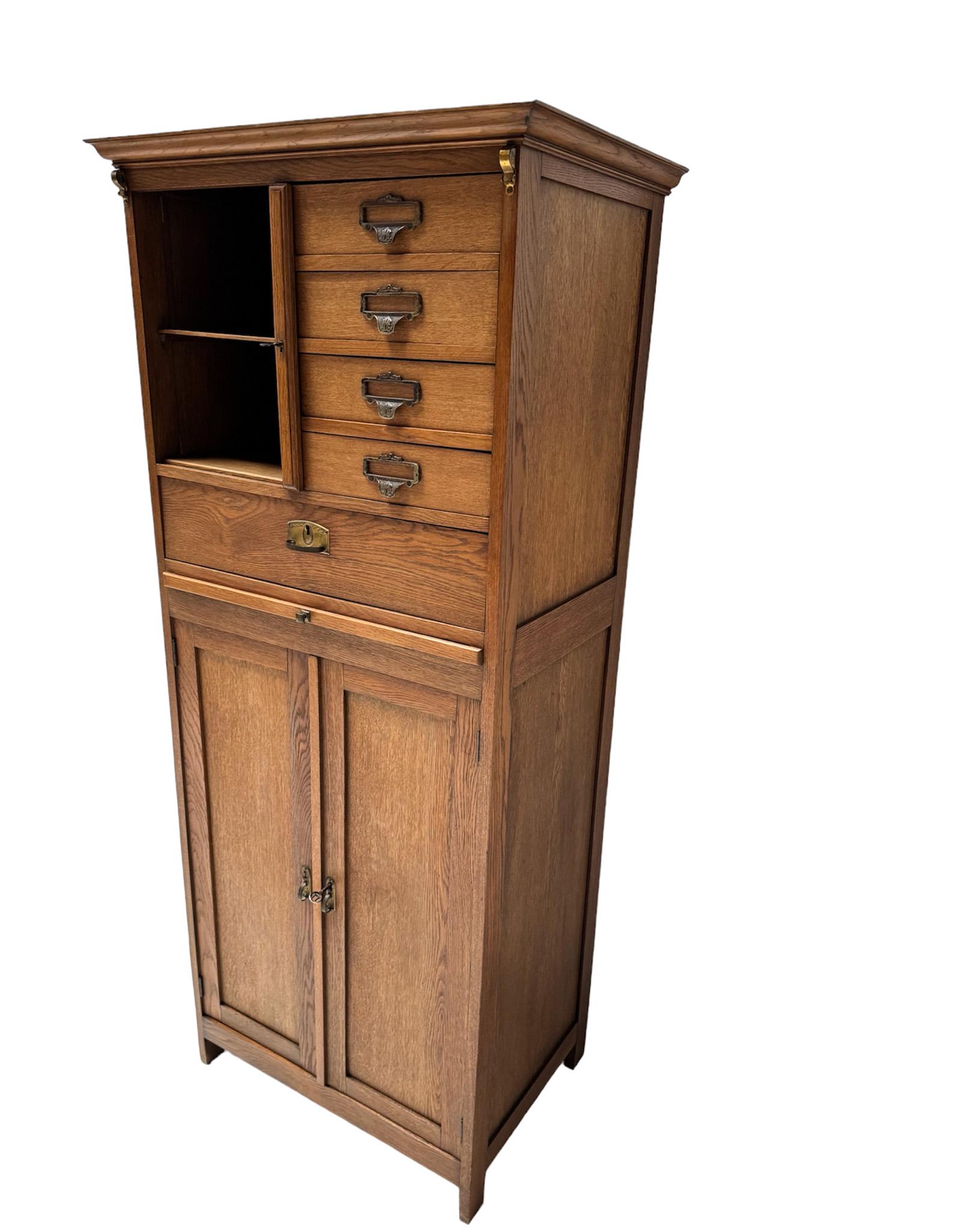 Magnificent and rare Art Nouveau filing cabinet or bookcase.
Striking Dutch design from the 1900s.
Solid oak base with five original drawers and one original pull out shelf.
Behind the two doors with the original brass handles, two original solid
