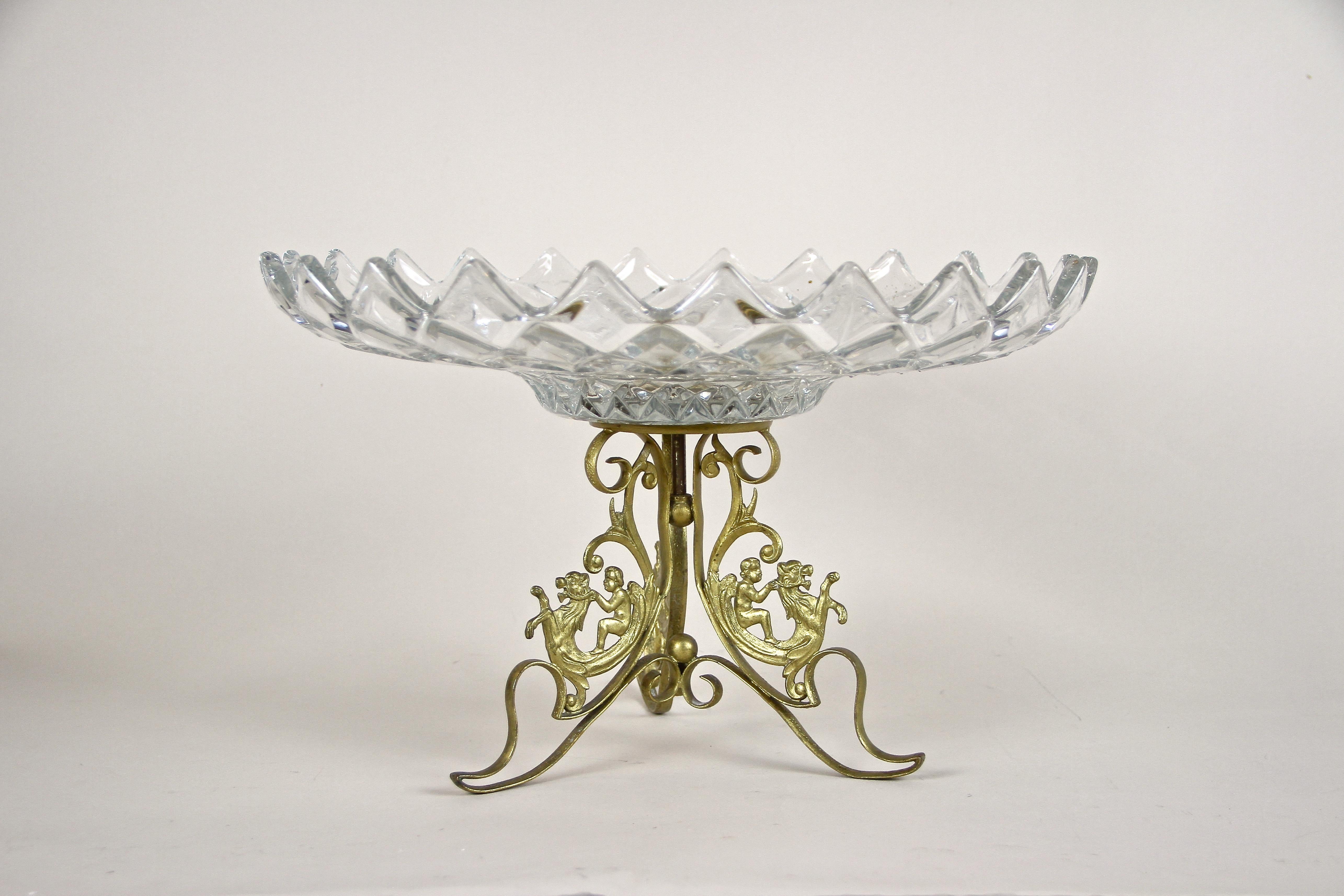 Delicate Art Nouveau centerpiece with wide cut glass bowl on top. Artfully designed in the period around 1910 in France, this lovely centerpiece impresses with a beautiful curved fire-gilt brass base depicting angels riding on mythical creatures.