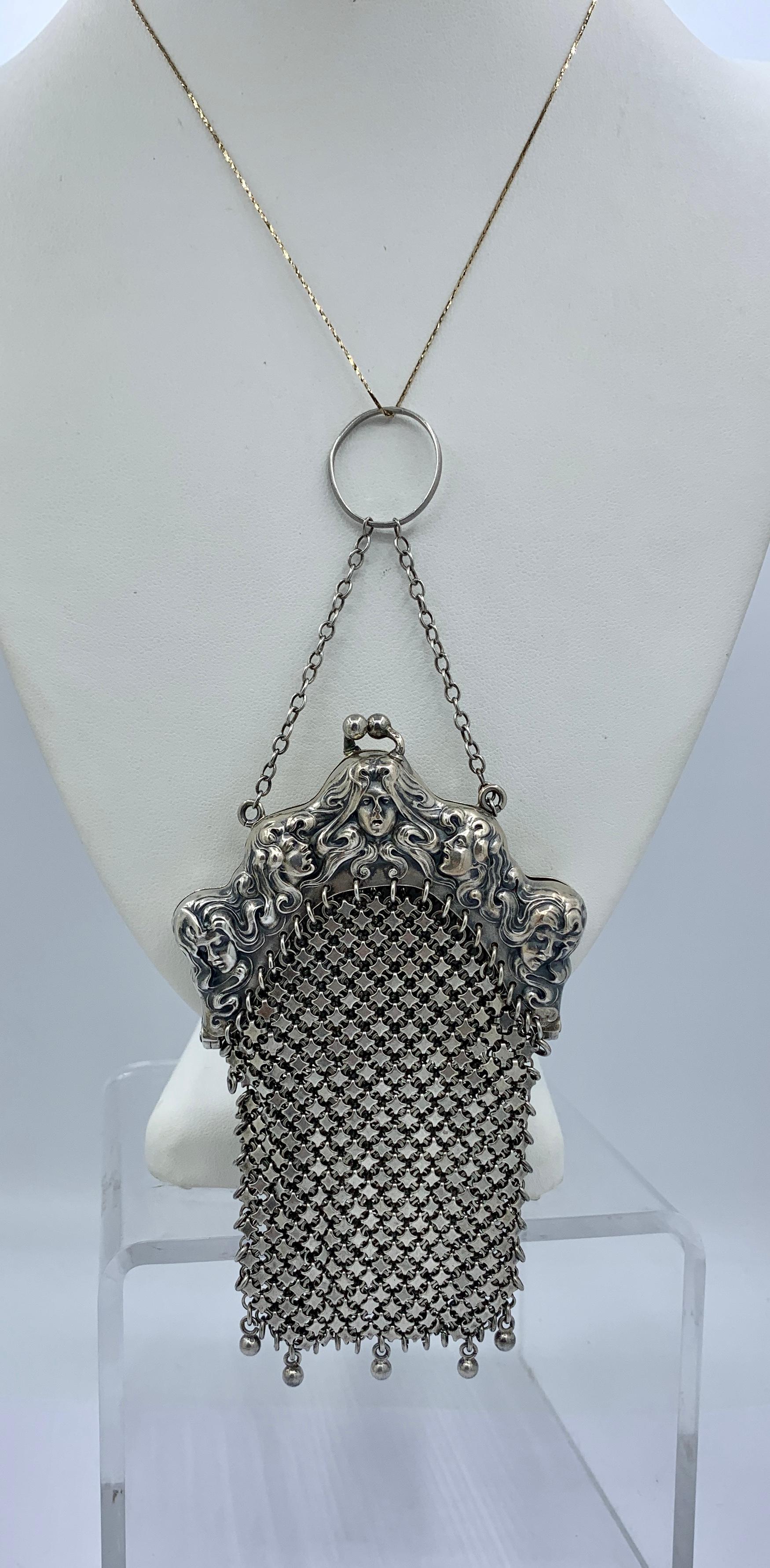 THIS IS AN EXTREMELY RARE STERLING SILVER LADIES HANDBAG OF EXTRAORDINARY BEAUTY WITH THE FACES OF FIVE WOMEN MAIDENS WITH EXTRAORDINARY FLOWING HAIR THAT ENCIRCLES AND ENTWINES THE FIVE MAIDENS BY THE ESTEEMED MAKER UNGER BROTHERS.  THE MESH SILVER