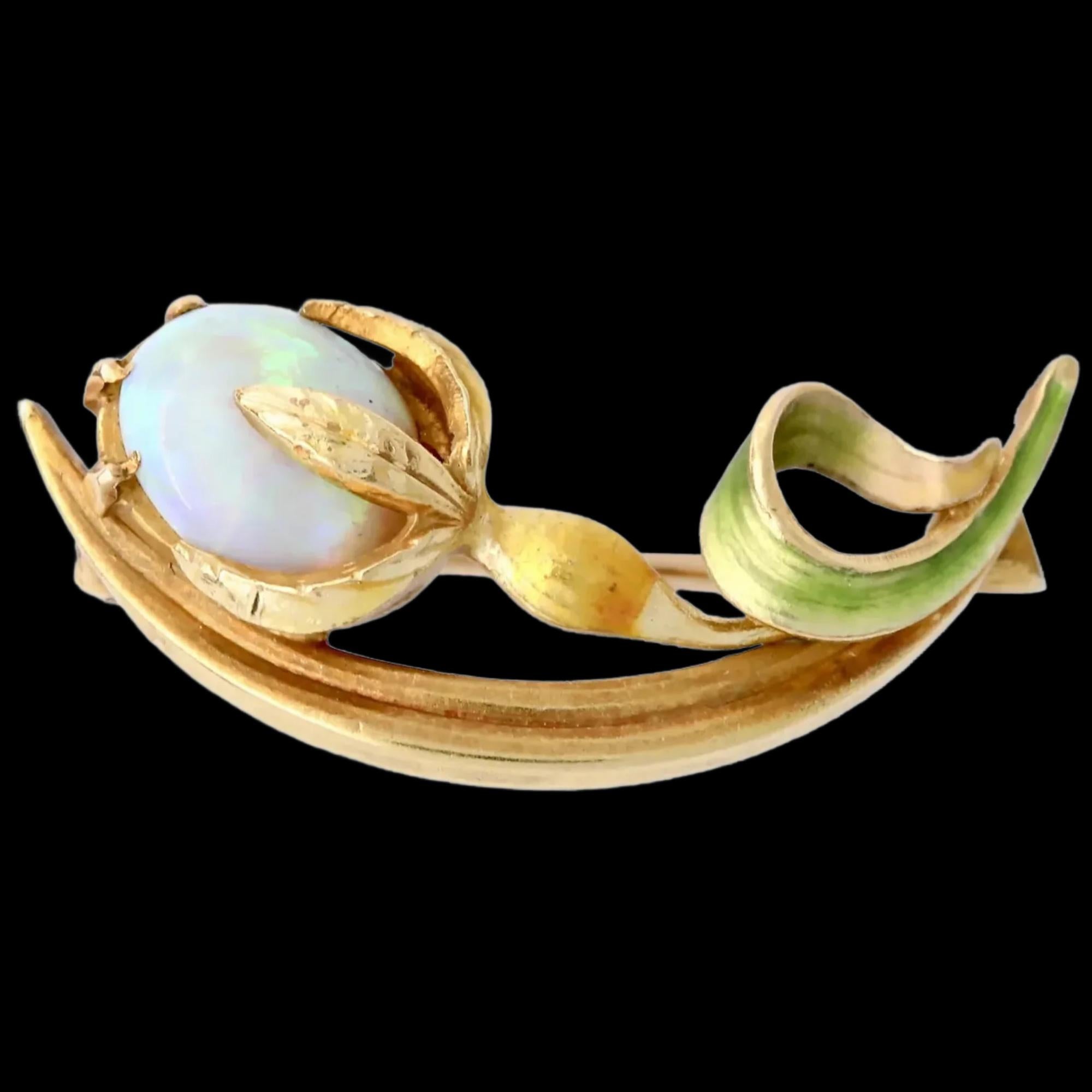 
A handmade art nouveau period enameled flower brooch centered by an Australian opal.

The leaves, and stem of flower enameled in green and golden translucent enamel.

Hallmarked as 14 Karat gold, with Krementz signature.

Measurements: 1