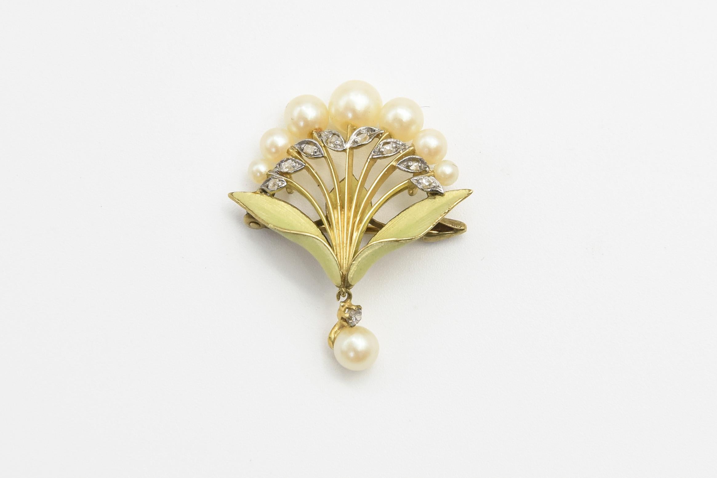 Stunning art nouveau enamel floral lily style spray brooch featuring seven graduating pearls on top of diamond and 18k yellow gold stems.  The brooch has two green enamel leaves that terminate with a diamond and pearl dangle.    The back has two
