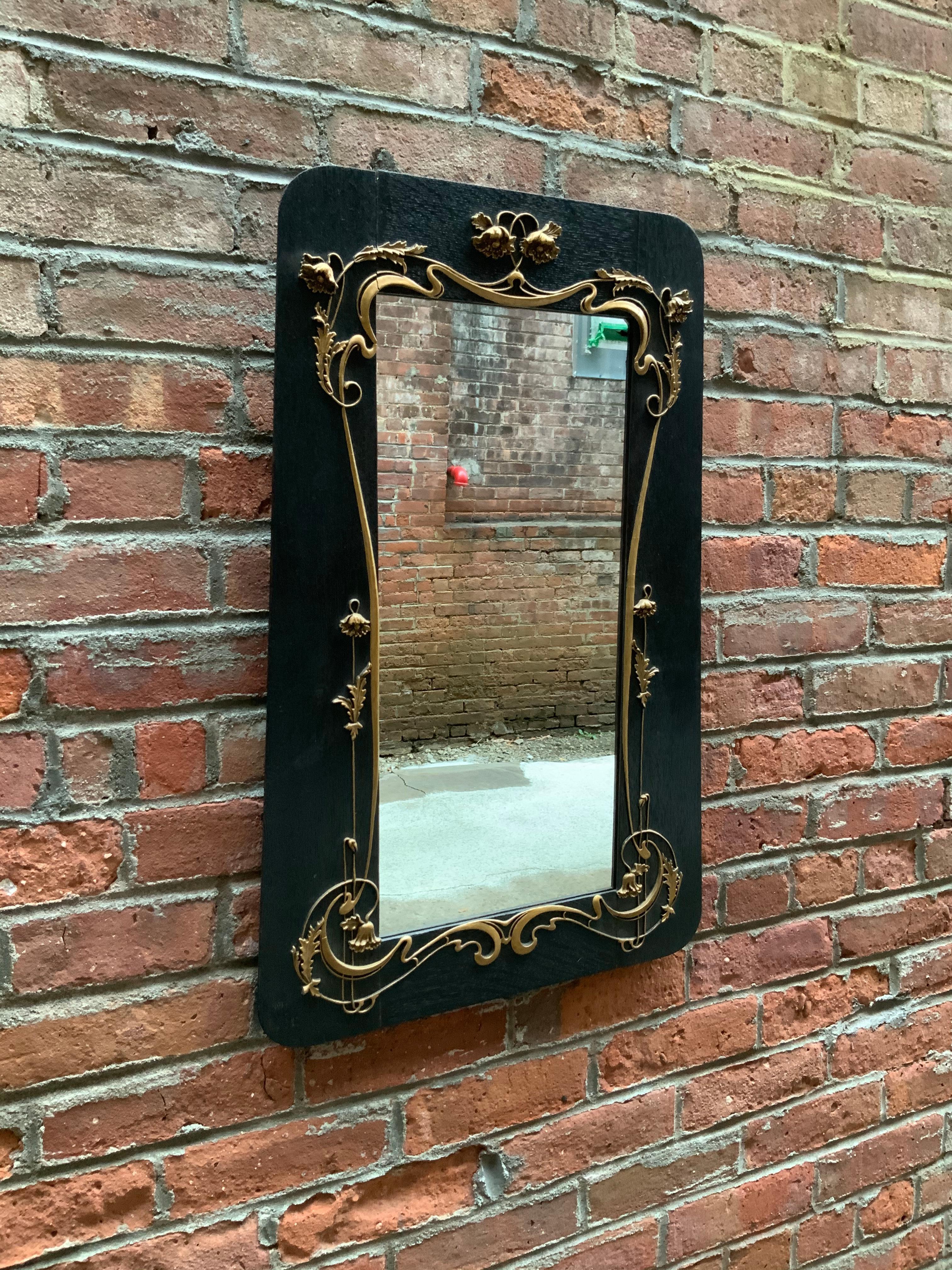 American Art Nouveau foliate and scroll decorated fumed oak mirror. Intricately gilded gesso decoration, circa 1890-1910. Slightly tapered profile. Very good condition with no visible losses to the gesso.

Approximate measurements are 26.88” high.