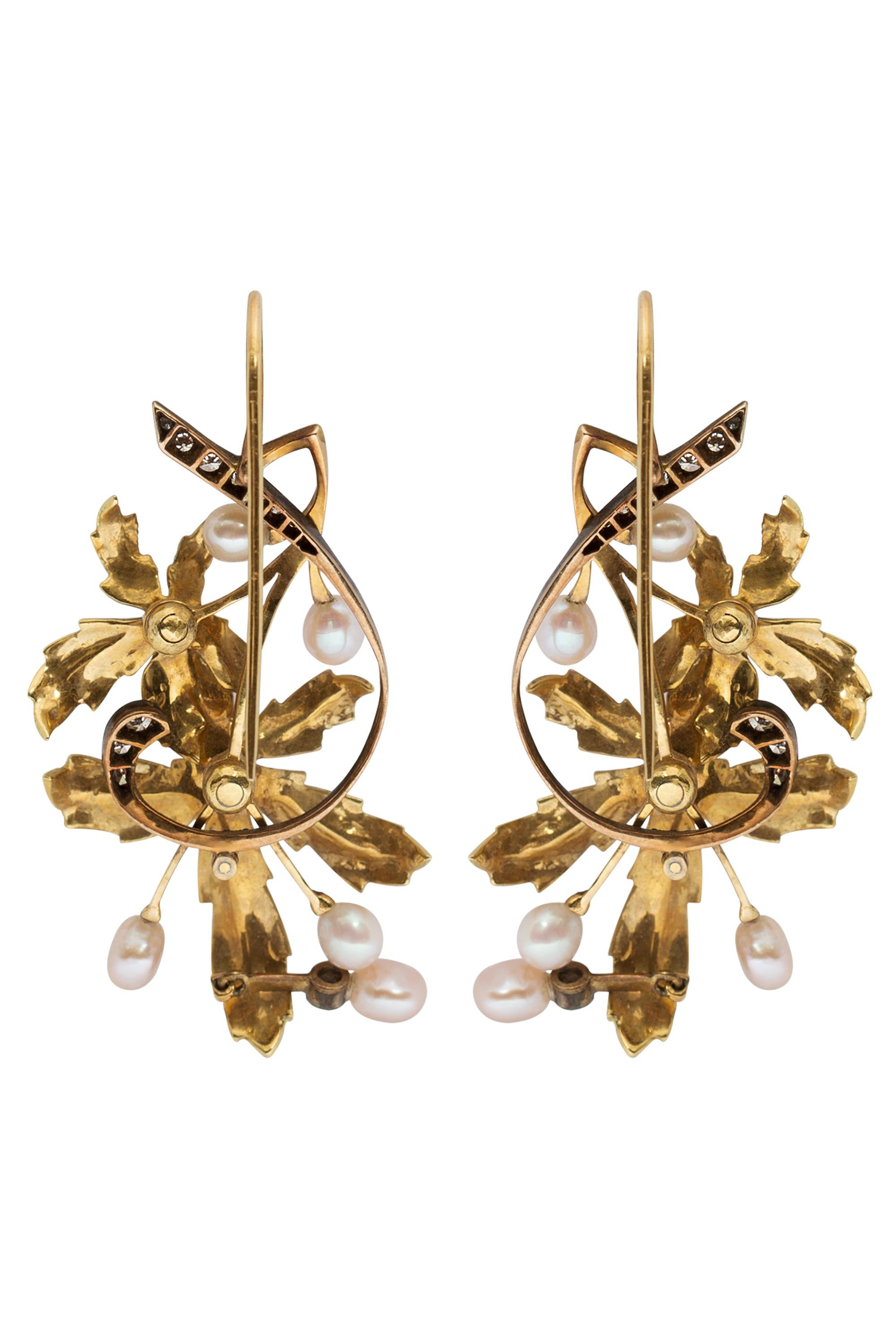 These delicate and graceful Art Nouveau earrings feature bright leaves of textured gold, sinuous curves of sparkling single cut diamonds set in delicate veins of blackened gold and a gentle cascade of luminous freshwater pearls. The incomparable