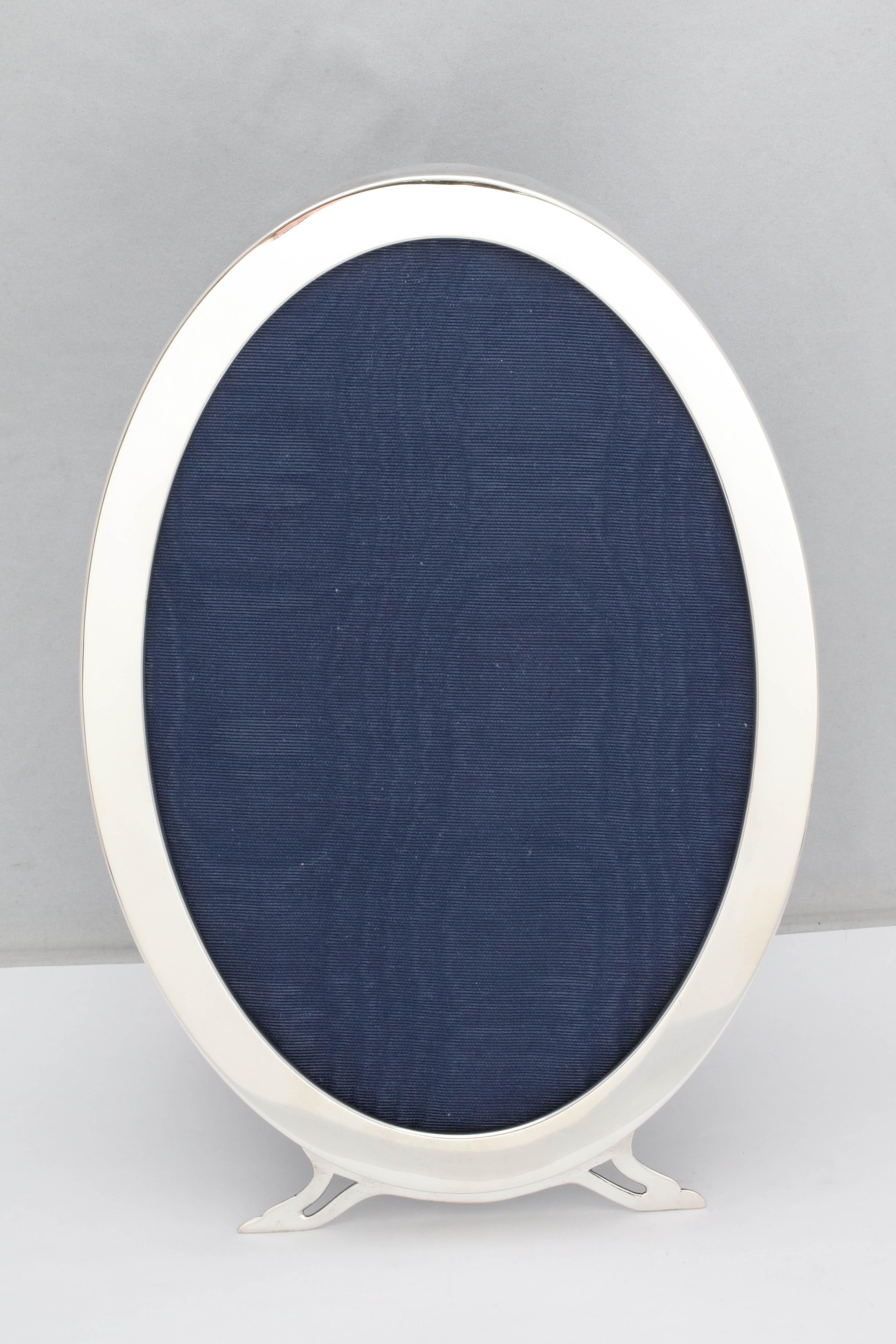 Grand, période Art Nouveau,  cadre ovale à pied en argent sterling avec dos en velours bleu, Londres, année 1907, Sebastian Henry Garrard - fabricant. Des pieds gracieux. Mesure 11 1/4 pouces de haut x 7 1/4 pouces de large x 5 3/4 pouces de