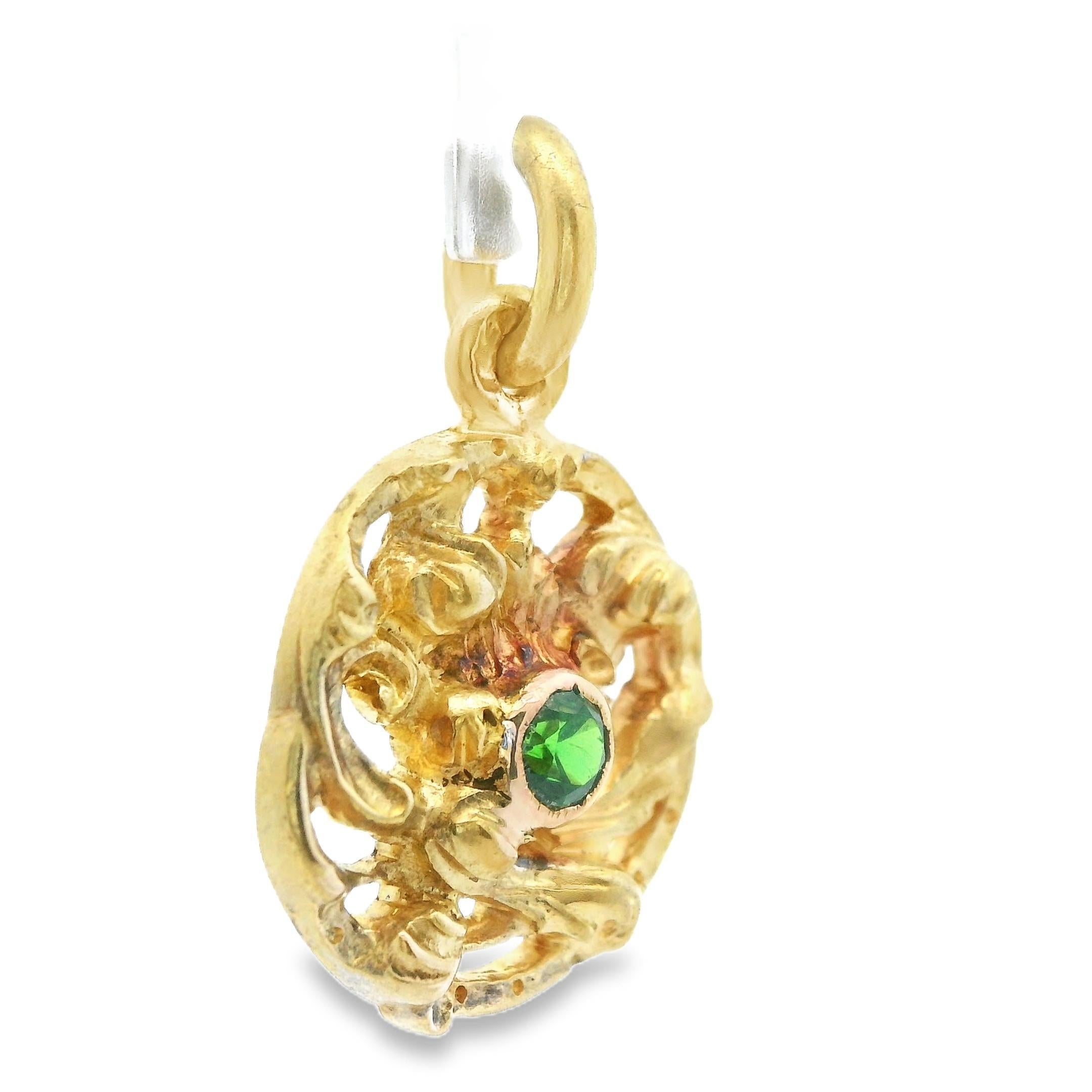 This beautiful pendant comes from the French Art Nouveau period, circa 1880, and is made in 18k yellow gold with stunning vivid green demantoid. The circle shaped pendant features hand engraved 18k yellow gold that is laid in a beautiful floral