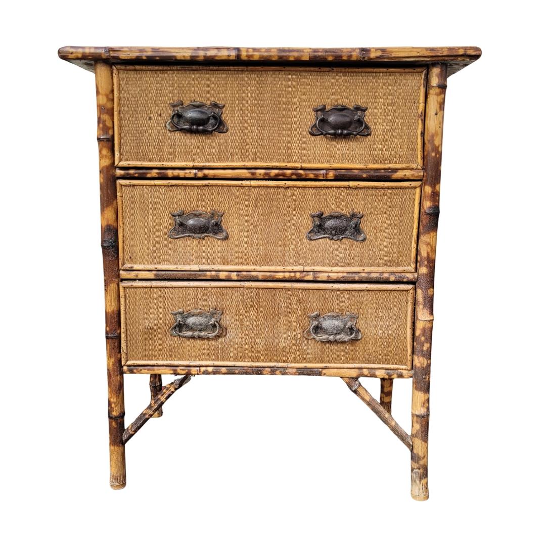 Wunderschöne und exotische Kommode aus Bambus und Rattan mit Eisengriffen im orientalischen Stil, die aus dem Frankreich des frühen 20. Jahrhunderts stammt.

Die Kommode ist in drei sehr breiten Registern angeordnet, die über drei Paare von