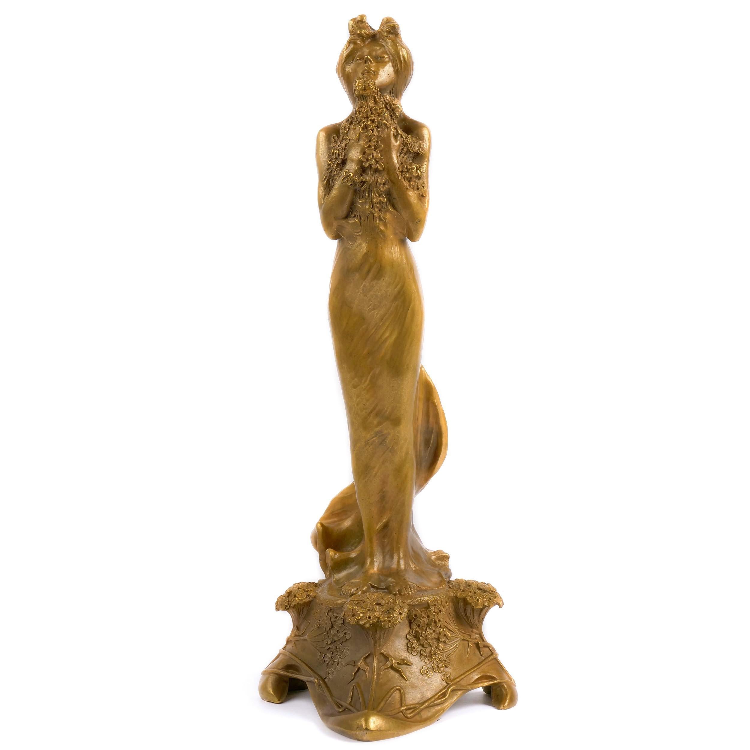 An incredibly distinctive work typical of the Art Nouveau expression of naturalism, the sculpture is a celebration of youth and the female form. The figure grasps bountiful bundles of flowers that overflow from her arms as she is overwhelmed by the