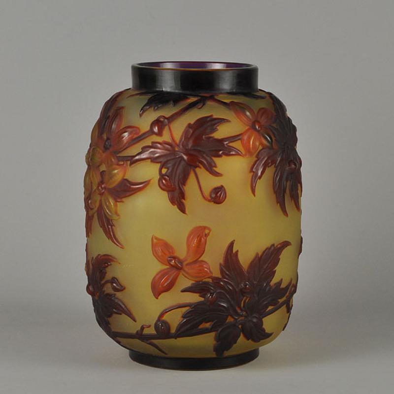 An eye-catching and rare early 20th century French cameo glass vase with a decorative mould blown design of flowering clematis in orange and red colors against a deep yellow field, signed Gallé. 



Emile Gallé (French, 1846 ~ 1904) born in